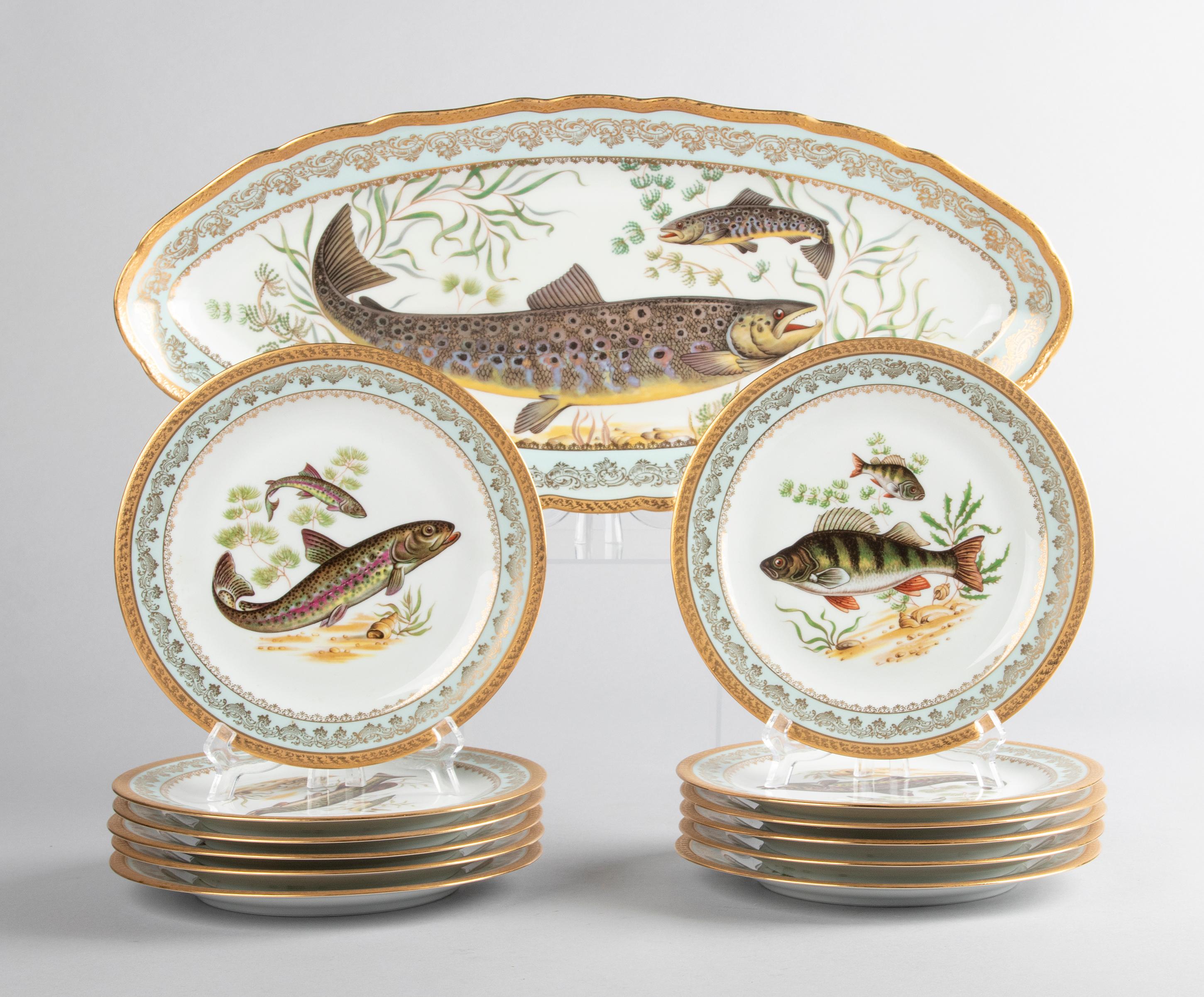 Beautiful set of porcelain fish service for 12 people by the French brand Limoges. The set consists of twelve plates, all decorated with different images of fish, and a large oval serving dish. The service has beautiful mint green edges with gold