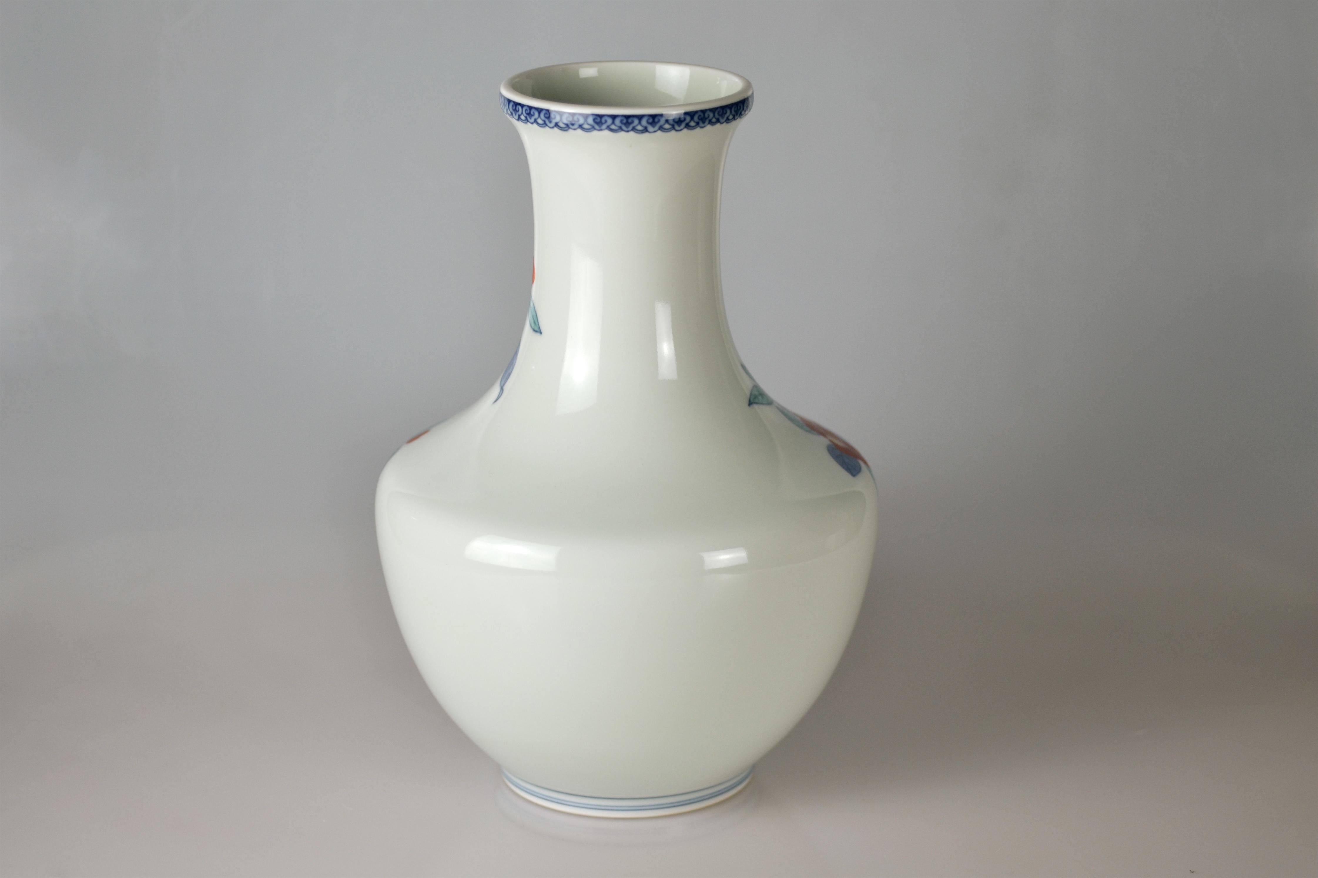 Excellent porcelain flower vase with camellia decor which is painted in underglaze blue and overglaze red, green and yellow. The vase was made by Imaizumi Imaemon XIII (1926-2001), who was designated a Living National Treasure of Japan for his