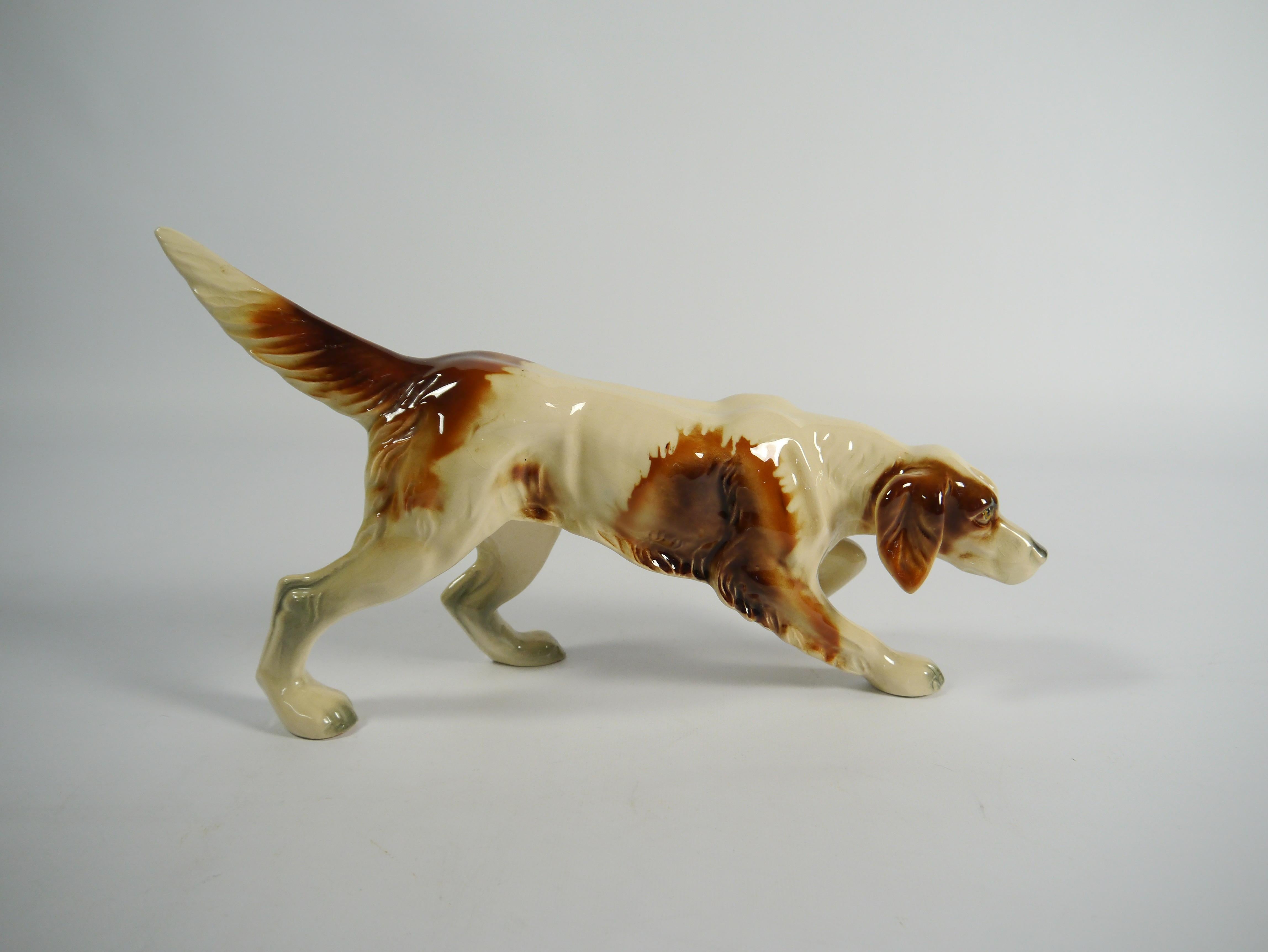 Porcelain foxhound dog figurine, depicted in a lifelike hunting / searching pose. Beautifully crackled and patinated porcelain. Marked 