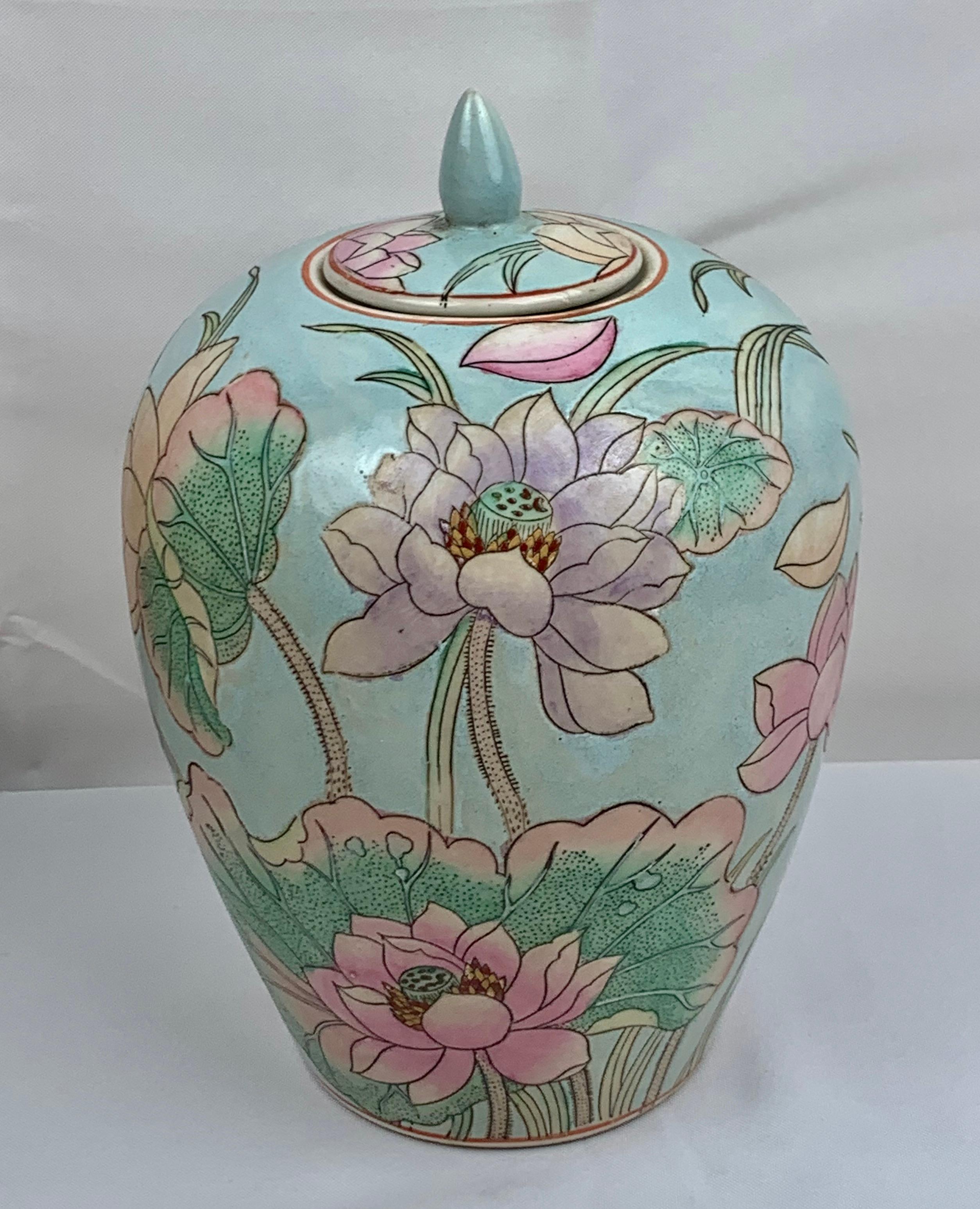 Ginger jar with lid hand painted in pastel colors. The motif is of exotic lotus blossoms on a pale aqua ground. This porcelain vessel could also be used as a vase, however, it stands alone as a decorative accessory.
Measures: H-10