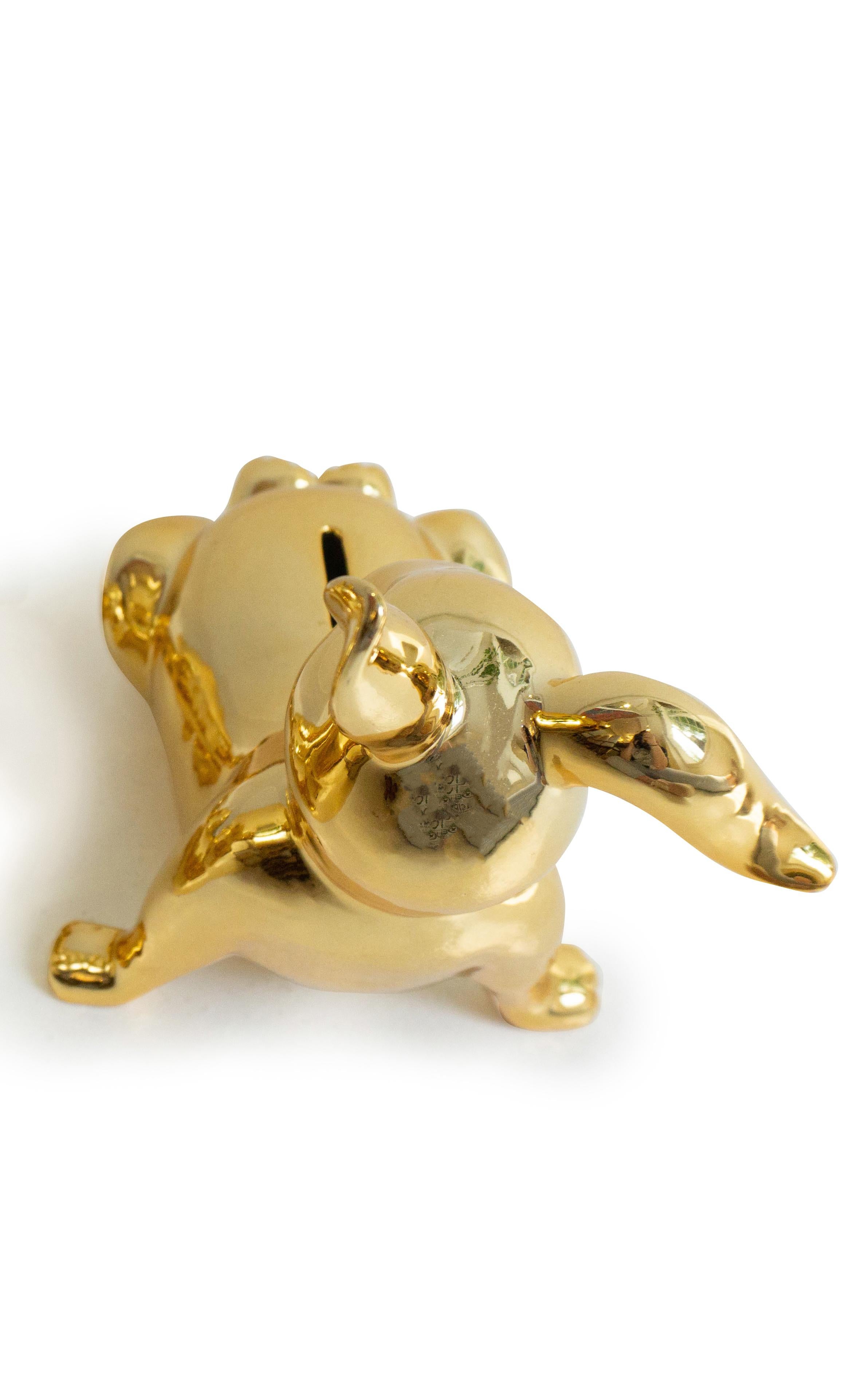 Porcelain gold money bank in the shape of a bunny. 

Dimensions: 7” H x 6” W x 8” L.