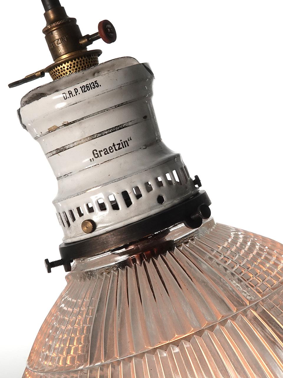 Questa lampada a gas appena cablata, firmata GRAETZIN, ha un piccolo corpo in porcellana bianca con un interessante anello di ritagli ventilati. Ha un paralume Holophane a coppa molto particolare con un diametro di 9 pollici. Queste tonalità sono