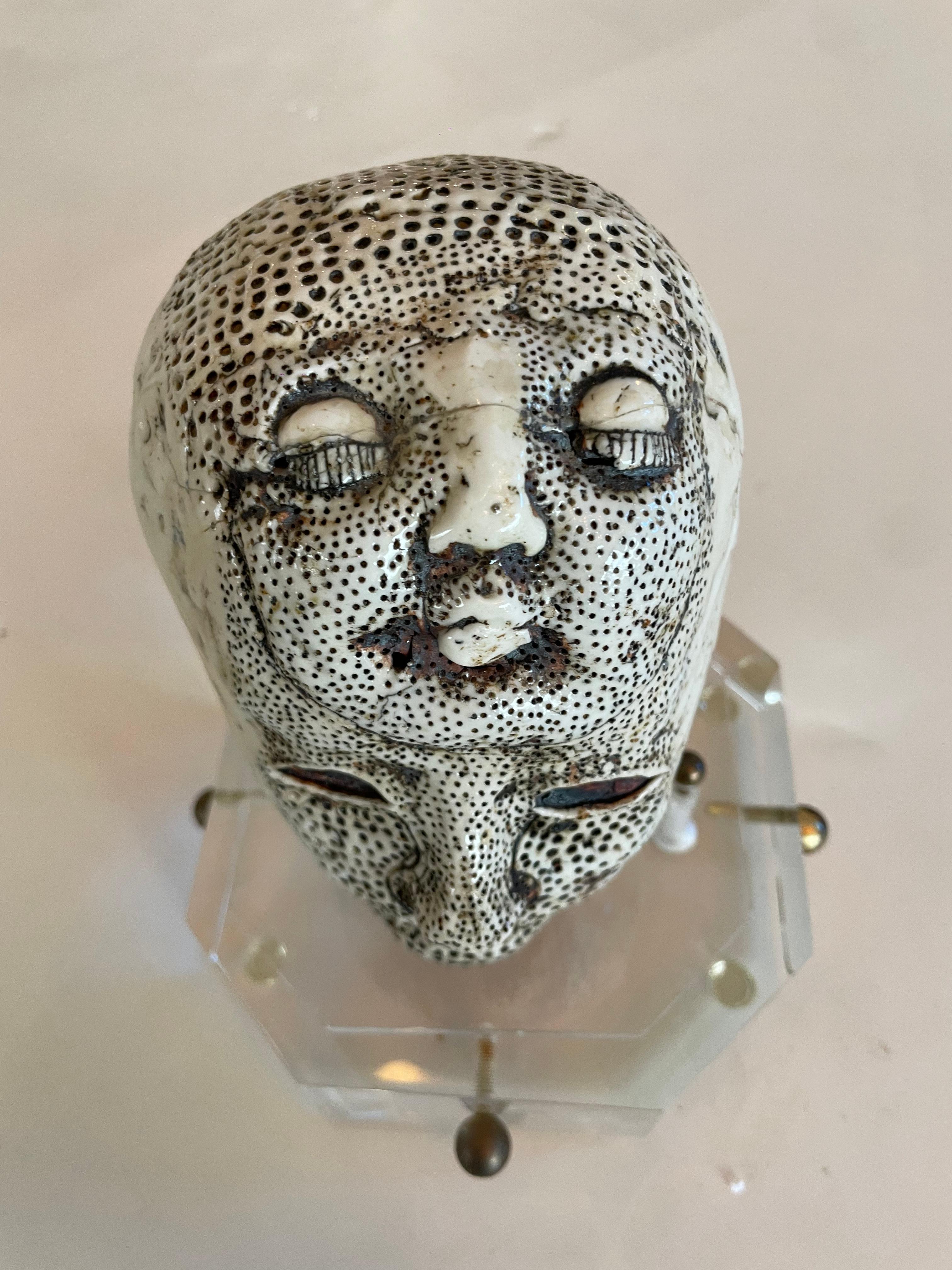 Most unbelievable porcelain sculpture head by Michele Oka Doner (American, born 1945). On lucite base with brass details.