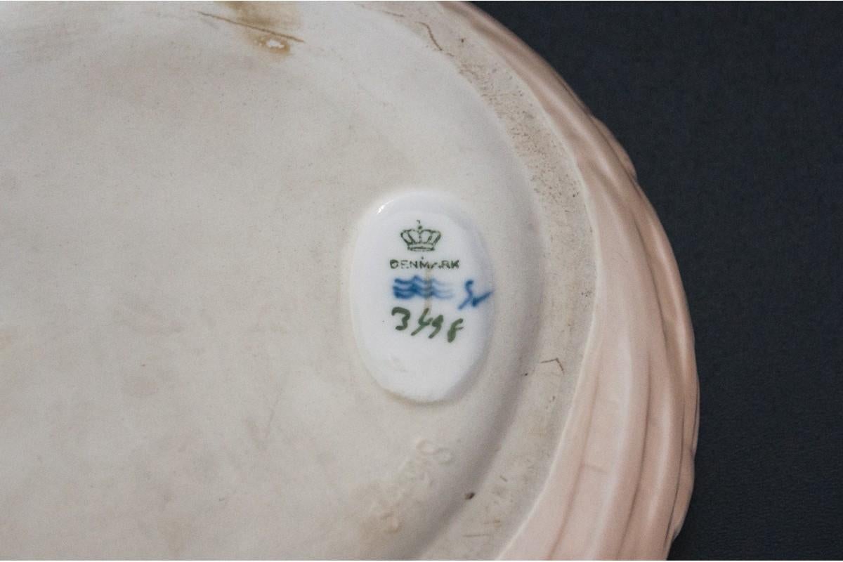 A vintage porcelain bowl featuring a gray lobster on the edge of the bowl.
The white porcelain is thick and its surface is colored with the typical for Royal Copenhagen, 