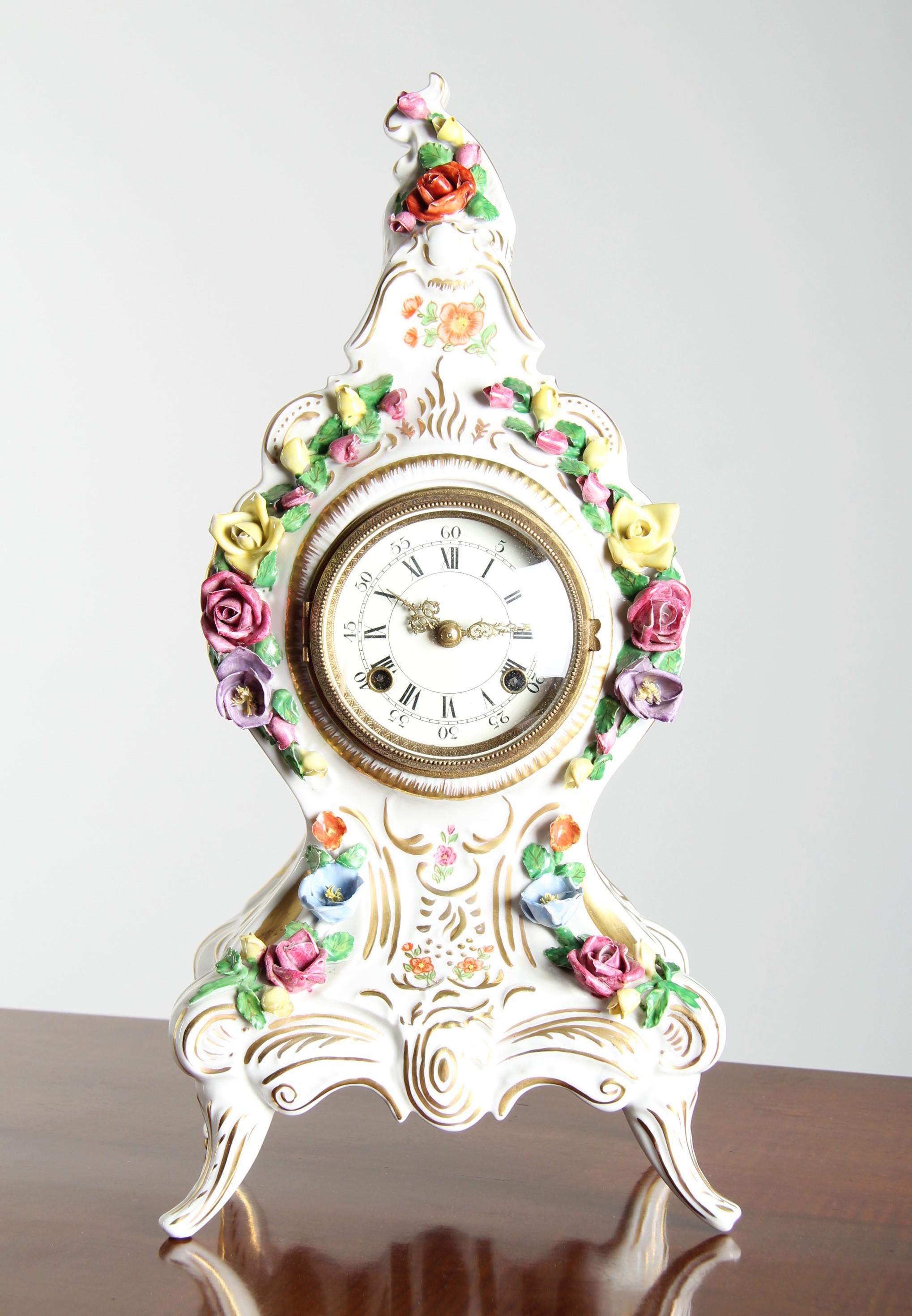 Kaminsimsuhr aus Porzellan mit aufgesetztem Blumendekor

Deutschland
Biskuitporzellan, polychrome Verzierung und Vergoldung
c. 1900

Abmessungen: H 44 × B 21 × T 15 cm

Beschreibung:
Aufwändig gearbeitete Kaminuhr aus weißem Porzellan mit reich