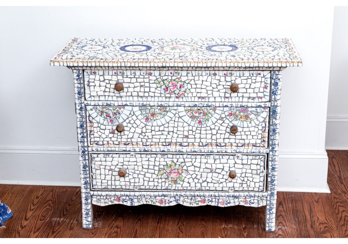 Kommode mit drei Schubladen und einer farbenfrohen und gut ausgeführten Mosaikintarsie mit lebhaften Blumenmotiven, die aus Porzellantellern und Porzellan besteht. Es verfügt über drei Schubladen mit Holzgriffen und kombiniert funktionale
