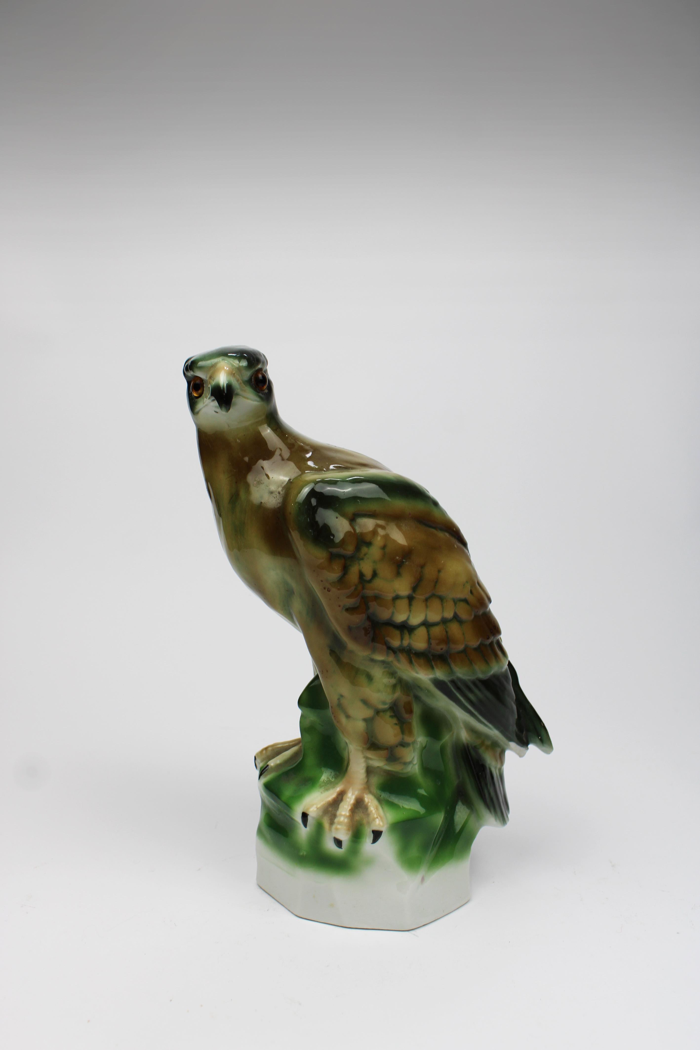 This exquisite Art Deco porcelain falcon, known as an Aerozon Perfume dispenser dates back to the 1920s Germany. The falcon is meticulously crafted, featuring lifelike glass eyes that enhance its elegant design. Marked on the bottom with 