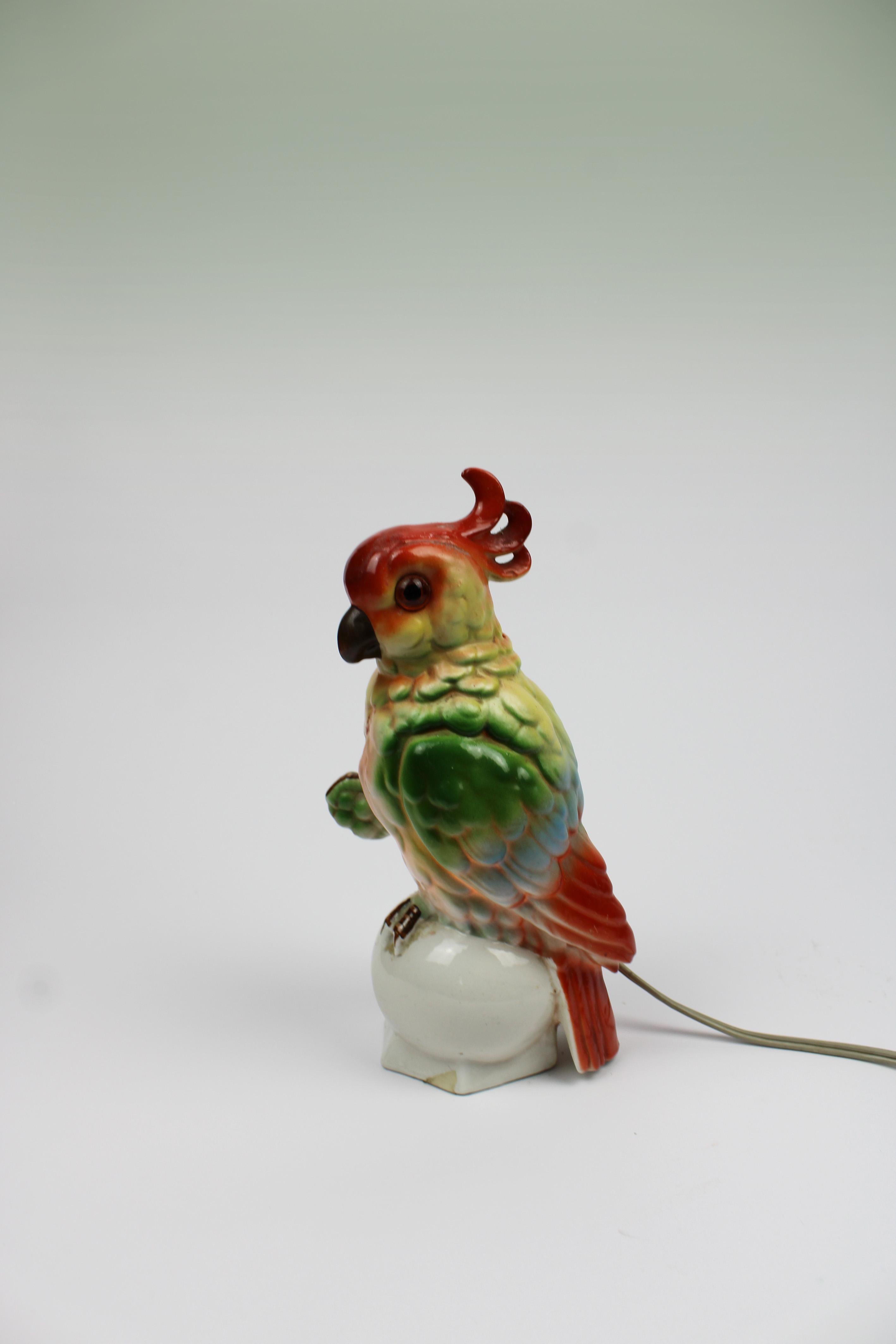 Introducing a stunning perfume lamp in the shape of a cockatoo, crafted as a sculpture with glass eyes. This exquisite piece dates back to the Art Deco period, renowned for its vibrant colors and bold designs. Functioning as both an animal statue