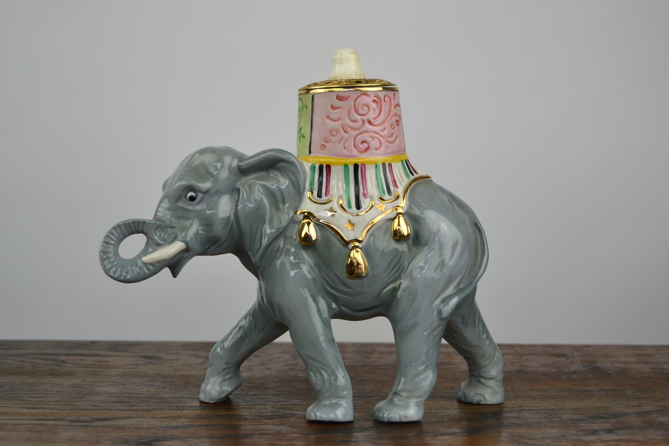 1950s Elephant Perfume Lamp made of porcelain. 
A cute looking Perfume Lamp - Perfume Light in the shape of an Elephant. 
It's a very beautiful and detailled elephant sculpture with eyes you can not resist and a colorful blanket and saddle on his