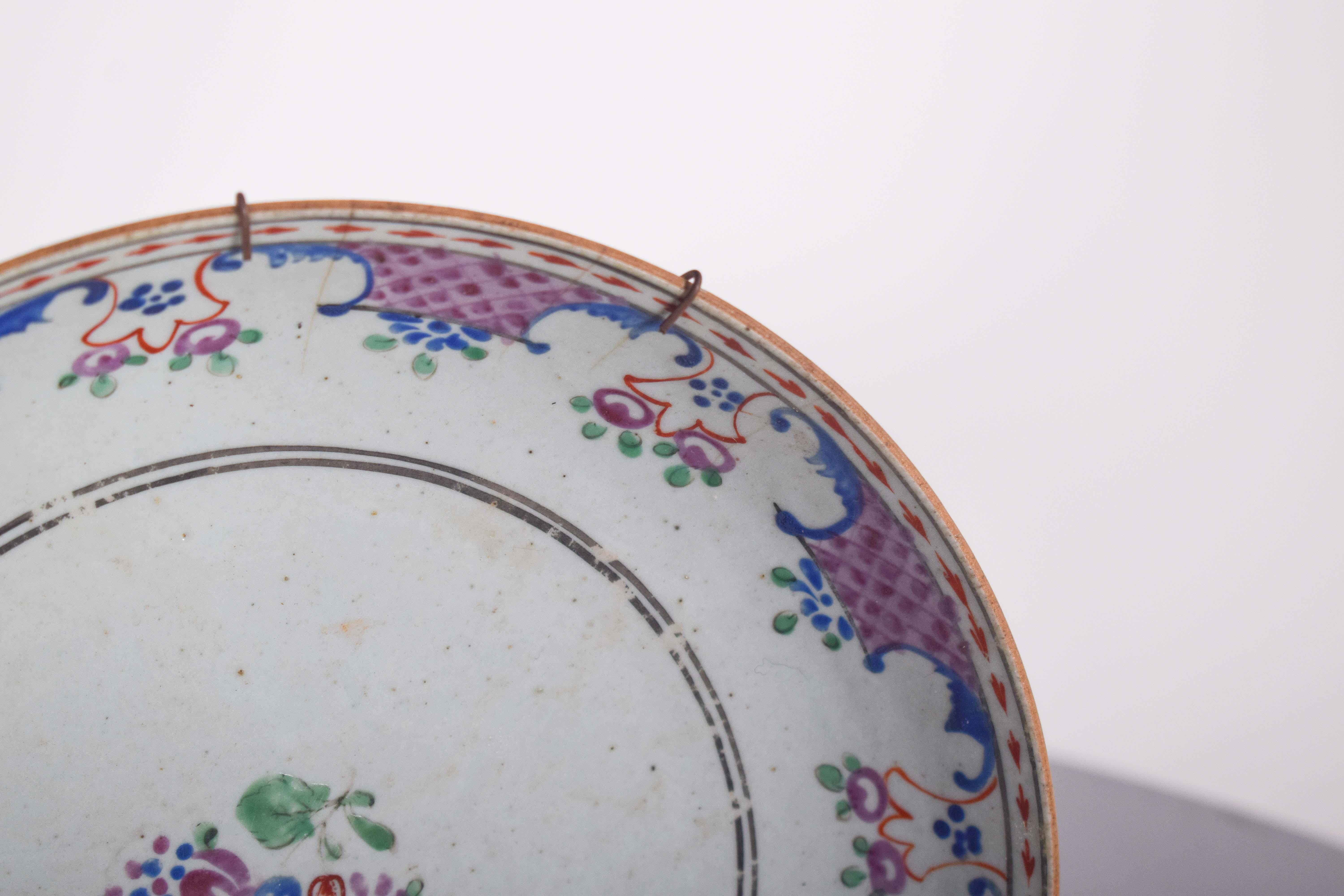 Plato de porcelana china para la exportación. Decoración policroma con flores de diseño refinado y ornamentado, posiblemente de origen europeo, inspirada en manufacturas del siglo XVIII, como la porcelana francesa de Sèvres o la alemana de Meissen.