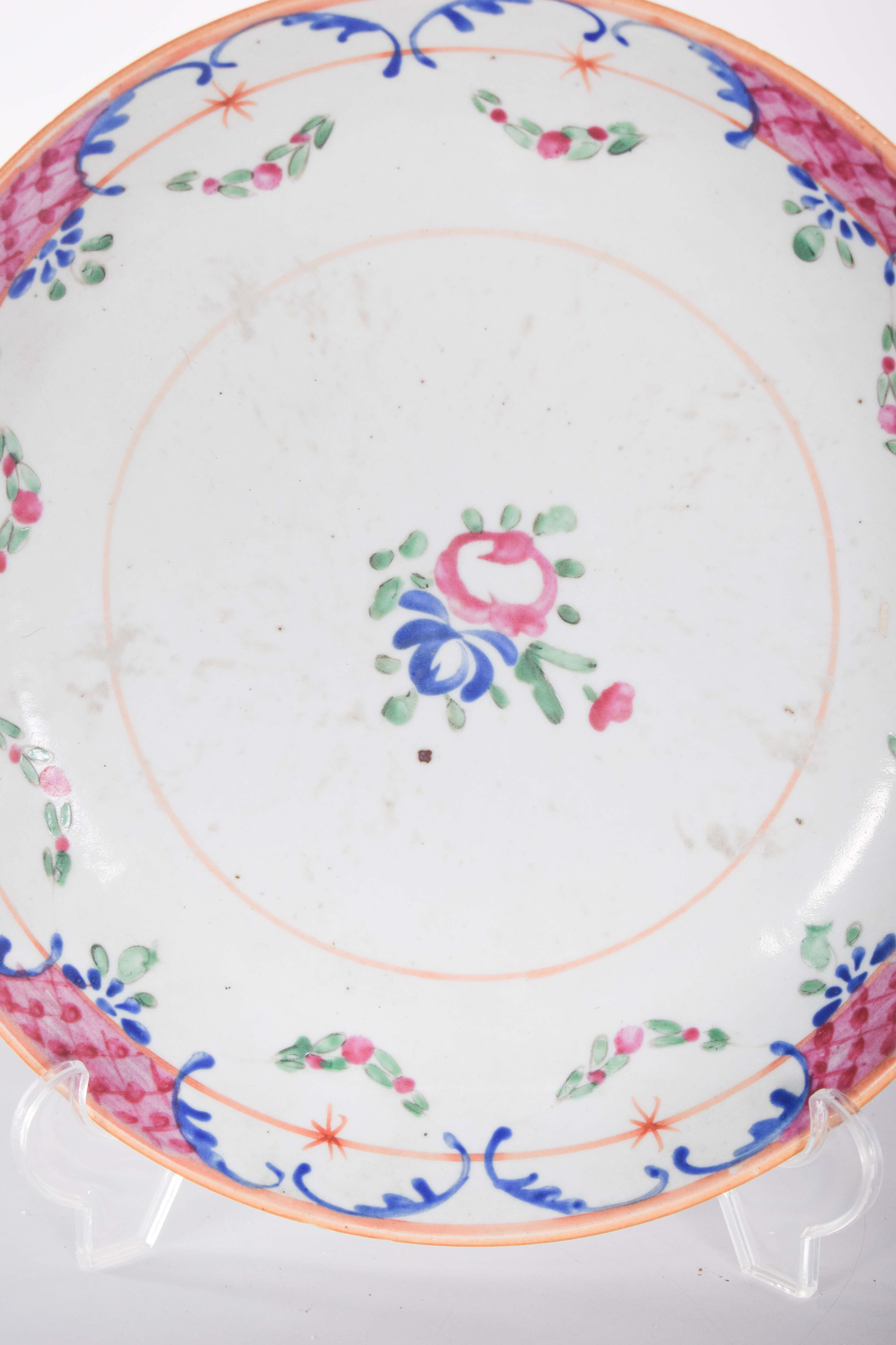 Porcelain plate from China for export. Decorated in shades of pink, blue, green and red, with roses in the center, surrounded by small leaves and a flower bud.
The rim of the plates is decorated with a symmetrical pattern of blue arabesques