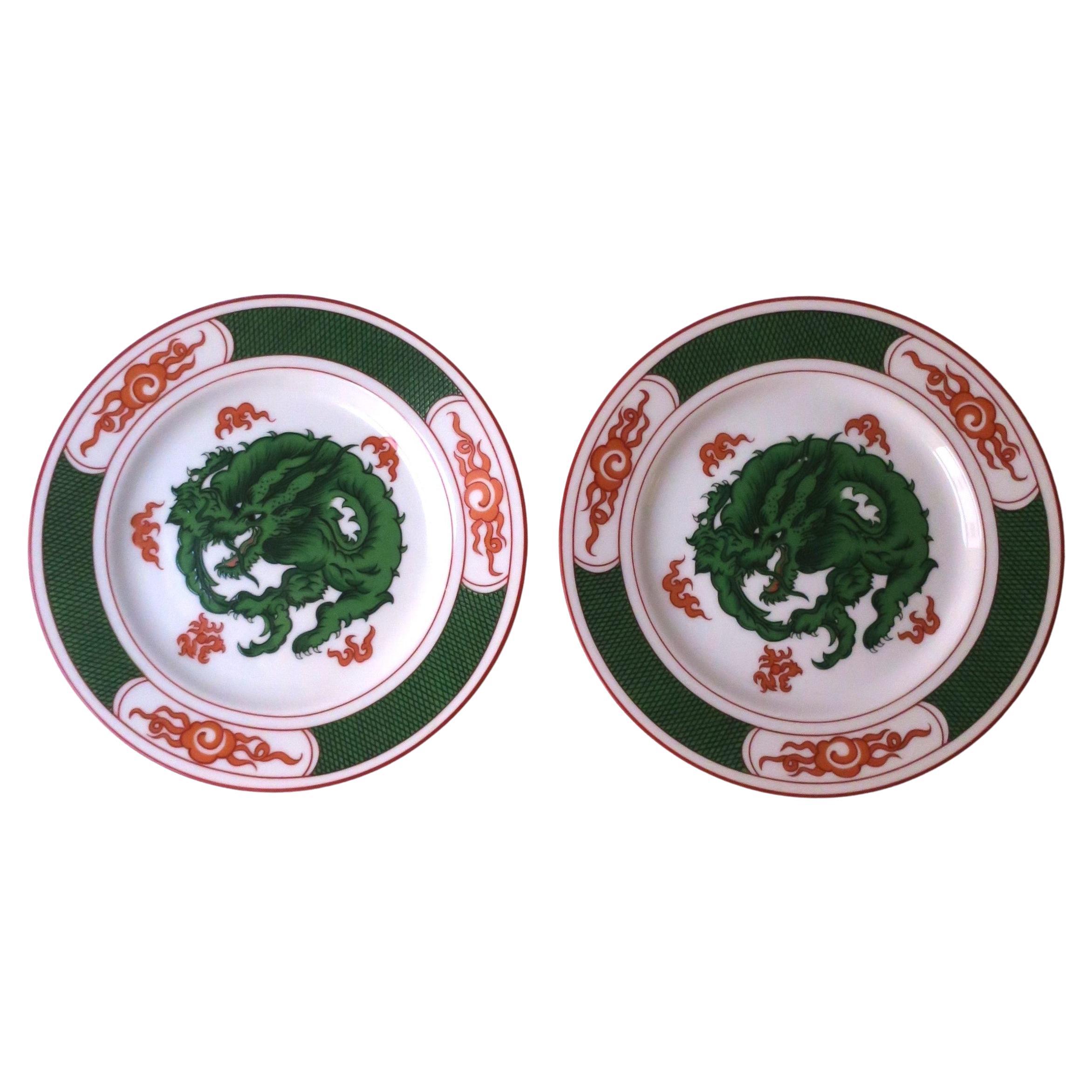A vintage pair of two (2) white porcelain plates with an emerald green dragon design at center and red/orange flames around, circa late-20th century, 1980s. Plates have a striking dragon design in beautiful green and red/orange flames hues around. A