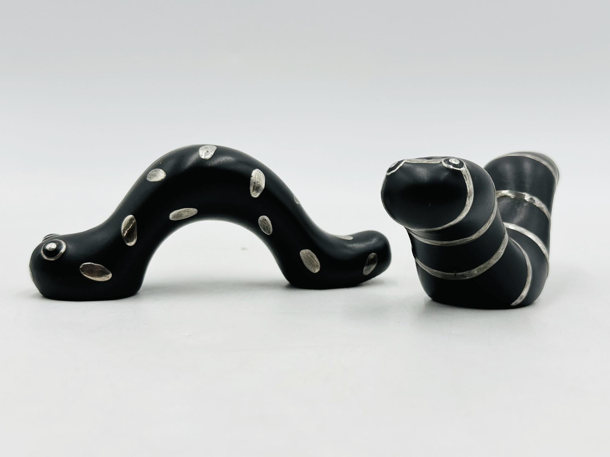 Vintage-Tischskulpturen aus Porzellan und reinem Silber, entworfen und hergestellt in Mexiko von Emilia Castillo.

Die Skulpturen stellen zwei Raupen aus schwarzem Porzellan mit reinem Silberdekor dar.

Die Skulptur trägt den Titel -La Oruga Muy