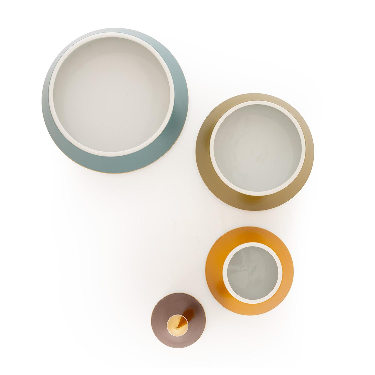 Esta pirámide de porcelana es realmente única. Diseñada en forma de cono, cada capa de colores se abre para dejar a la vista tus preciados objetos pequeños. Acabada en tonos apagados de marrón, verde, azul y mostaza con detalles chapados en oro, es