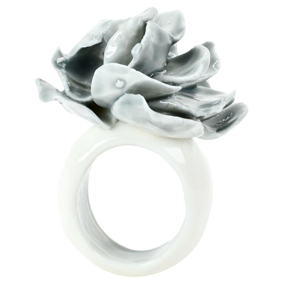Porcelain  Handmade in London

Introducing our exquisite porcelain ring, adorned with a delicate cloudy-colored rose meticulously hand-sculpted petal by petal. 
The ring is made from the purest, whitest porcelain. Cloudy gray glazed Interior 