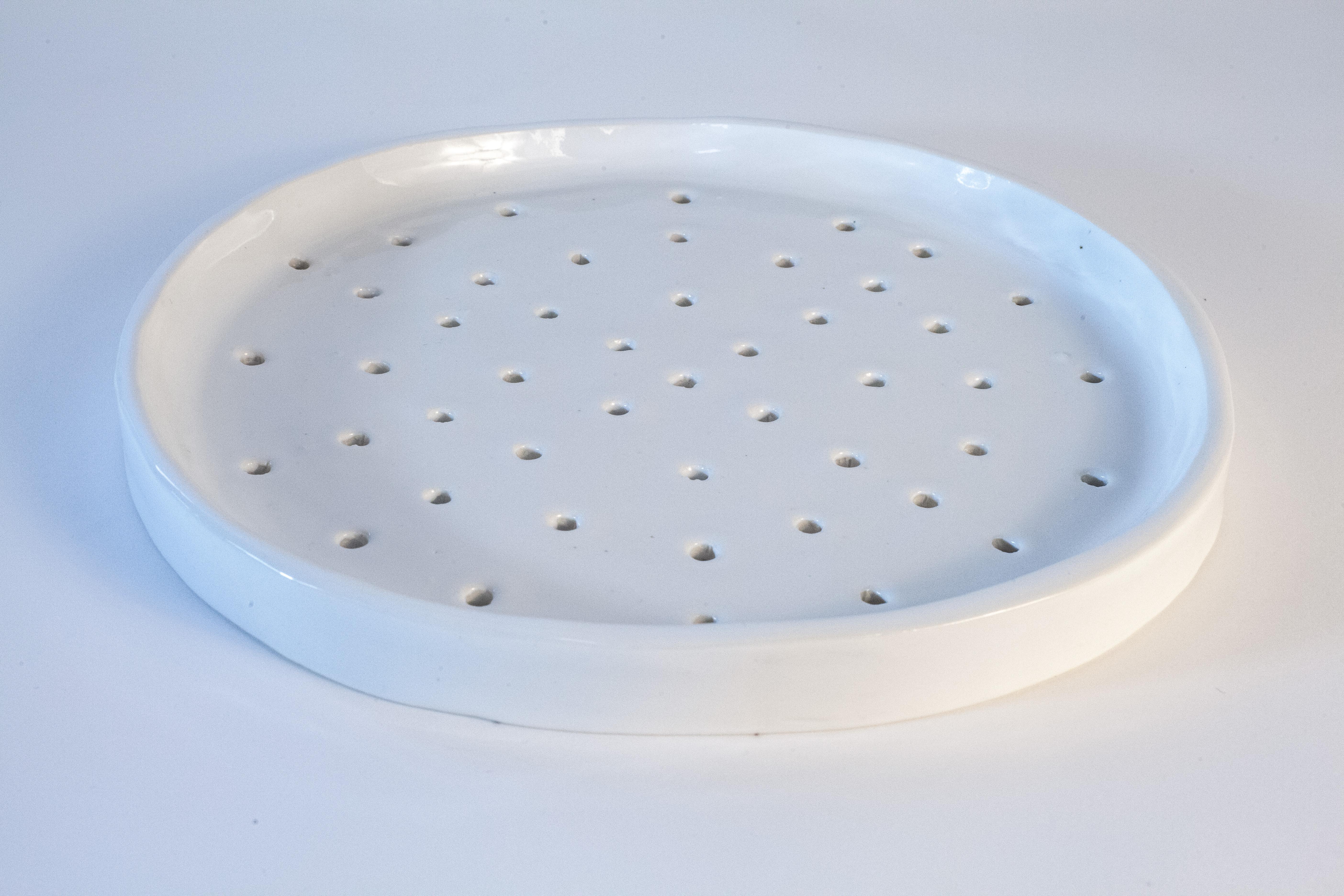 Hand-build porcelain sieve / tray by Danish artist, Christine Roland.
An organic shape with a hole pattern and glossy, white glazing
This one-of -a-kind, decorative object is also suitable as tableware: as a tea tray, an herb sieve or for flower
