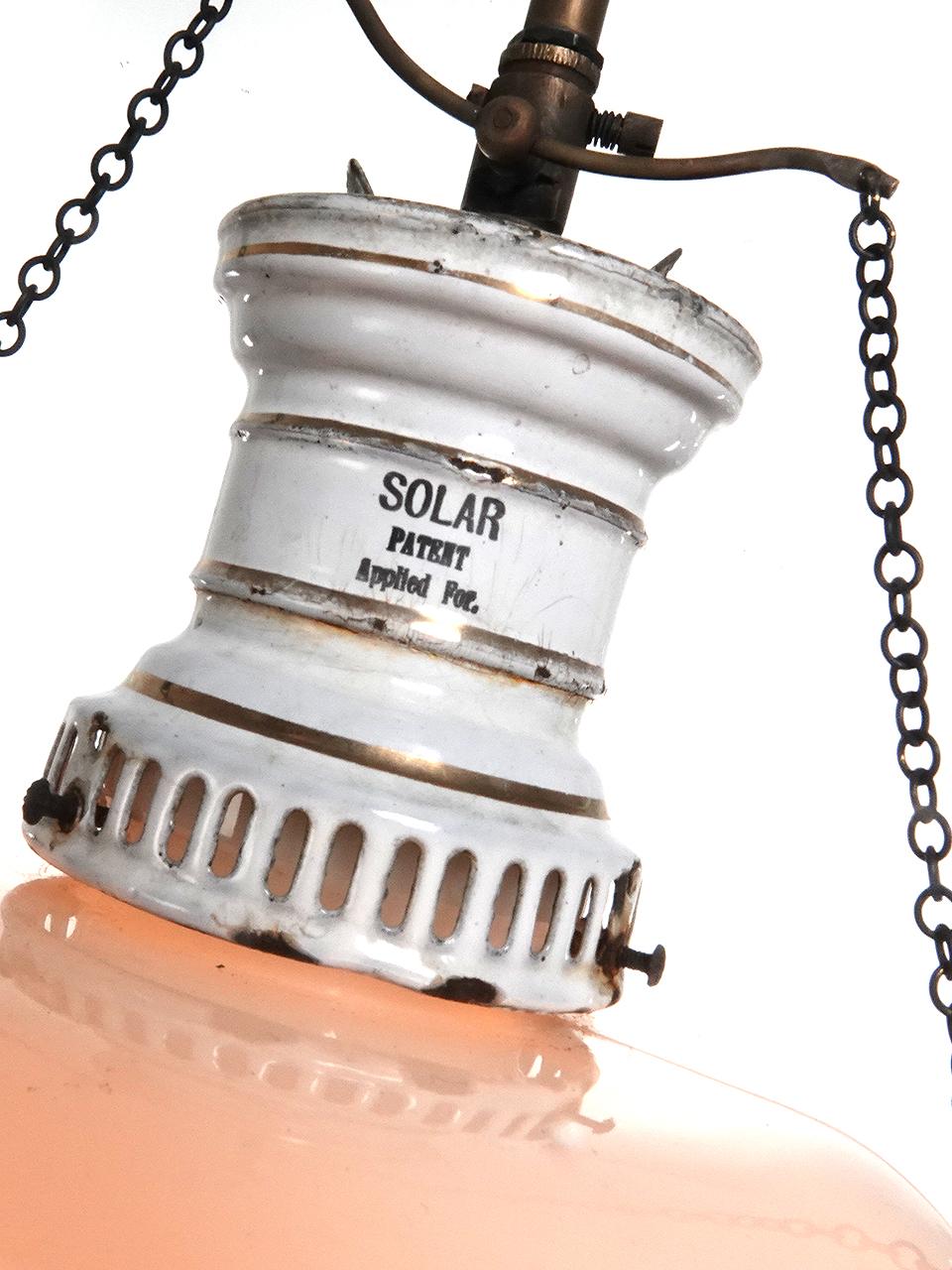 Questa lampada a gas appena cablata, firmata SOLAR, ha un piccolo corpo in porcellana bianca con un interessante anello di ritagli ventilati e l'originale valvola a gas seasaw e catene. Ha un interessante paralume in vetro lattiginoso con un fondo