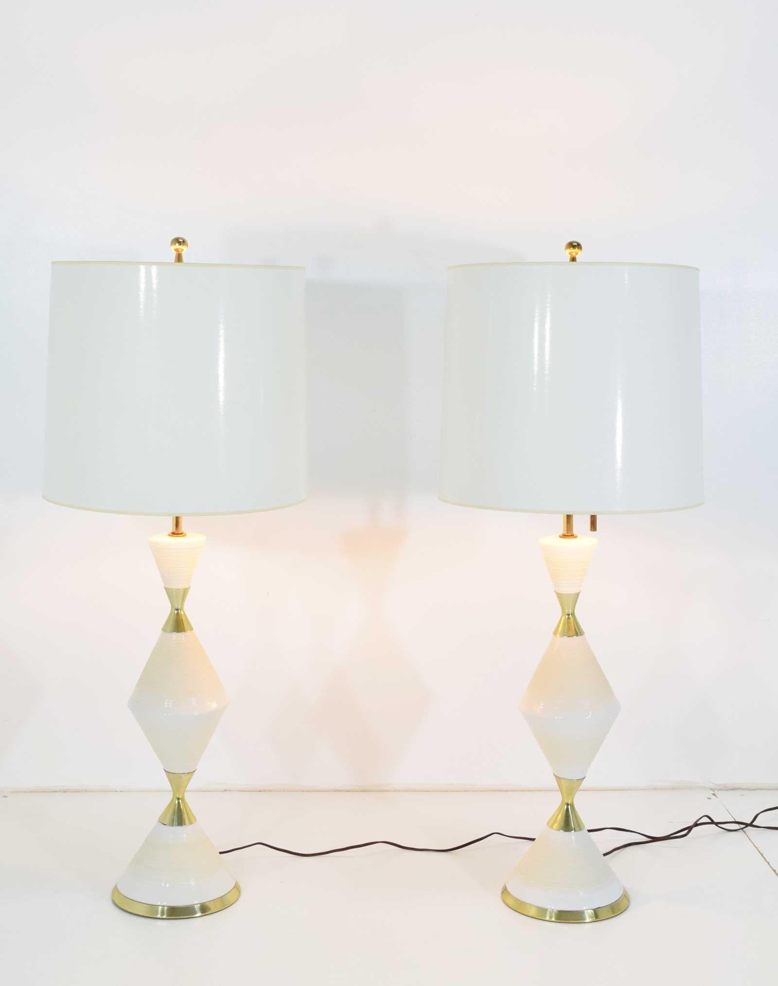 A stunning pair of vintage porcelain lamps by Gerald Thurston for Lightolier. Each lamp features brass fittings and three bulb fixture. We added the shades but you can change to your choice. 

Measurements exclude the shades.
