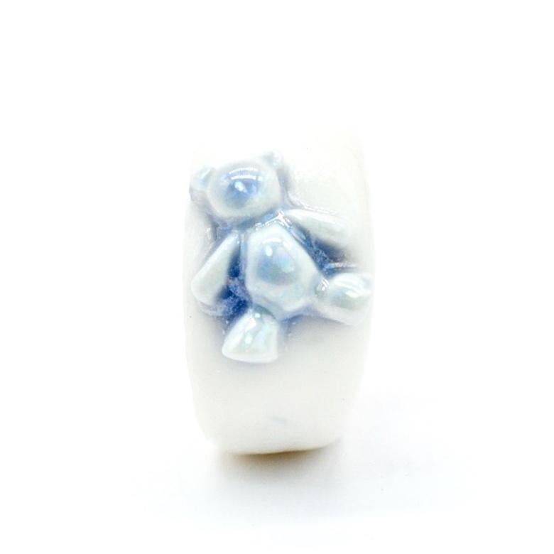 Porcelain  Mother of pearl  24K gold  Handmade in London

Introducing our TEDDY Porcelain Ceramic Ring - a truly unique and nostalgic piece. Made from porcelain and glazed with a powder blue hue, this ring features a delicate toy teddy bear. With an
