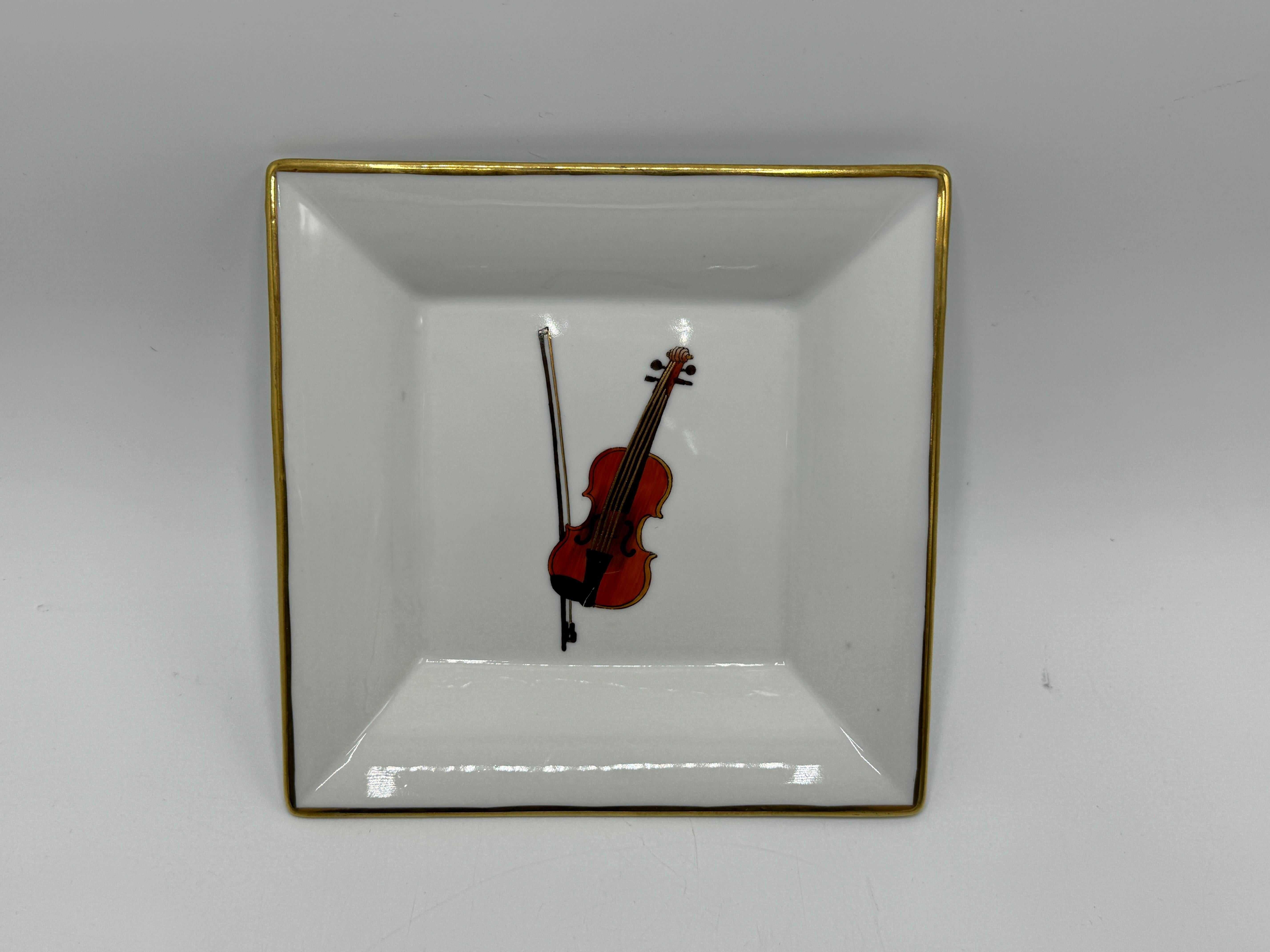 Offered is a fabulous, late 20th Century, porcelain valet or ring dish. The piece depicts a violin and and bow in the center with gold along the edge. The perfect objet for a musician or musical arts enthusiast. Heavy, weighing 1.2lbs. 