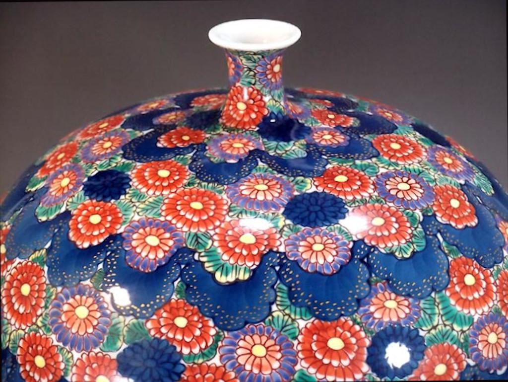 Japanese contemporary porcelain decorative vase, hand painted in vivid blue and red on an elegantly shaped ovoid porcelain body, a signed piece by highly acclaimed Japanese master porcelain artist in the Imari-Arita tradition. In 2016, the British