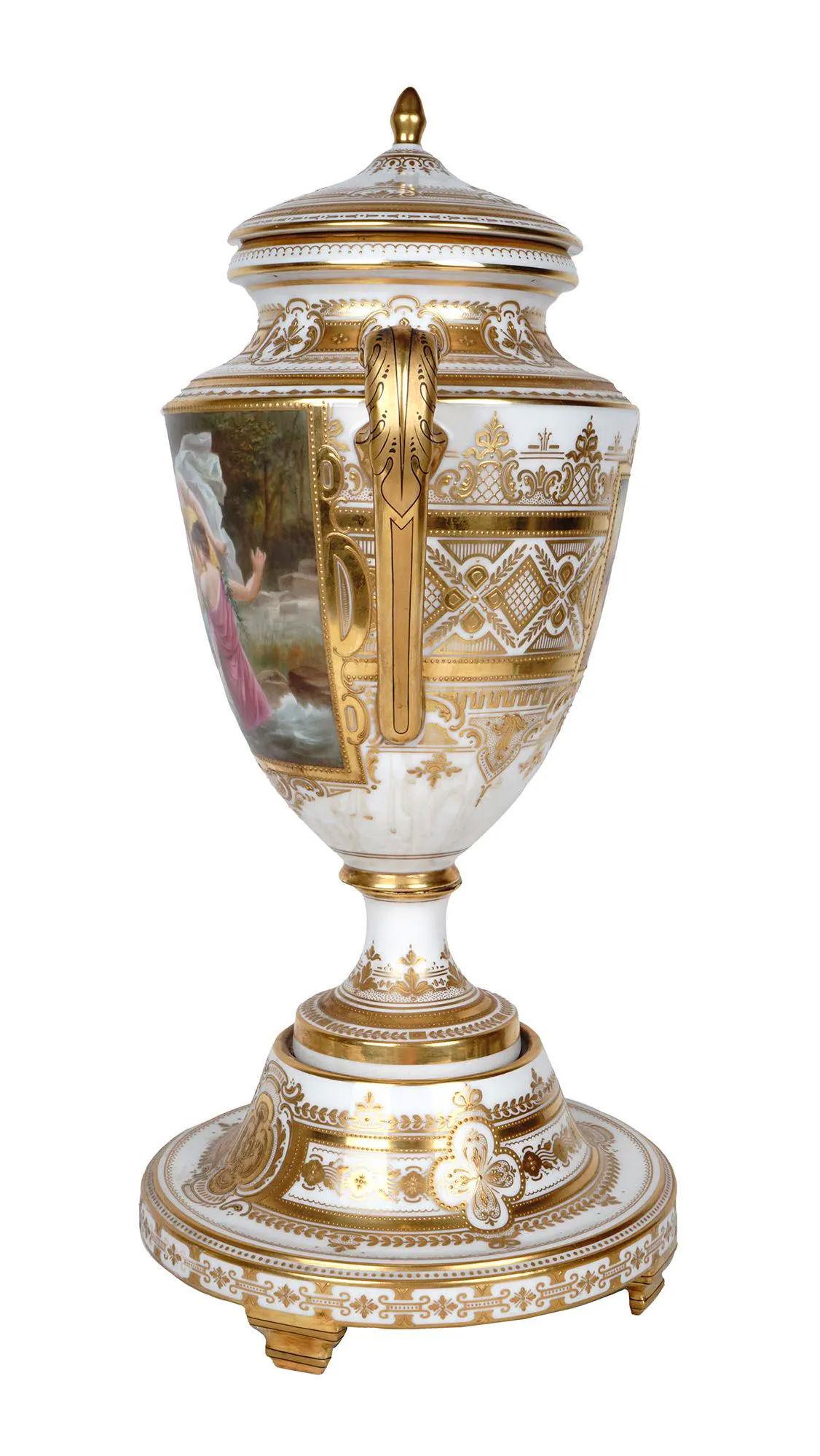 Our beautiful vase with cover from Vienna features finely painted cartouches depicting maidens signed Habel (or Haibel) and extensive gilding. With blue shield underglaze mark in blue and red marks 2086 with the title, Die Perle (The Pearl).