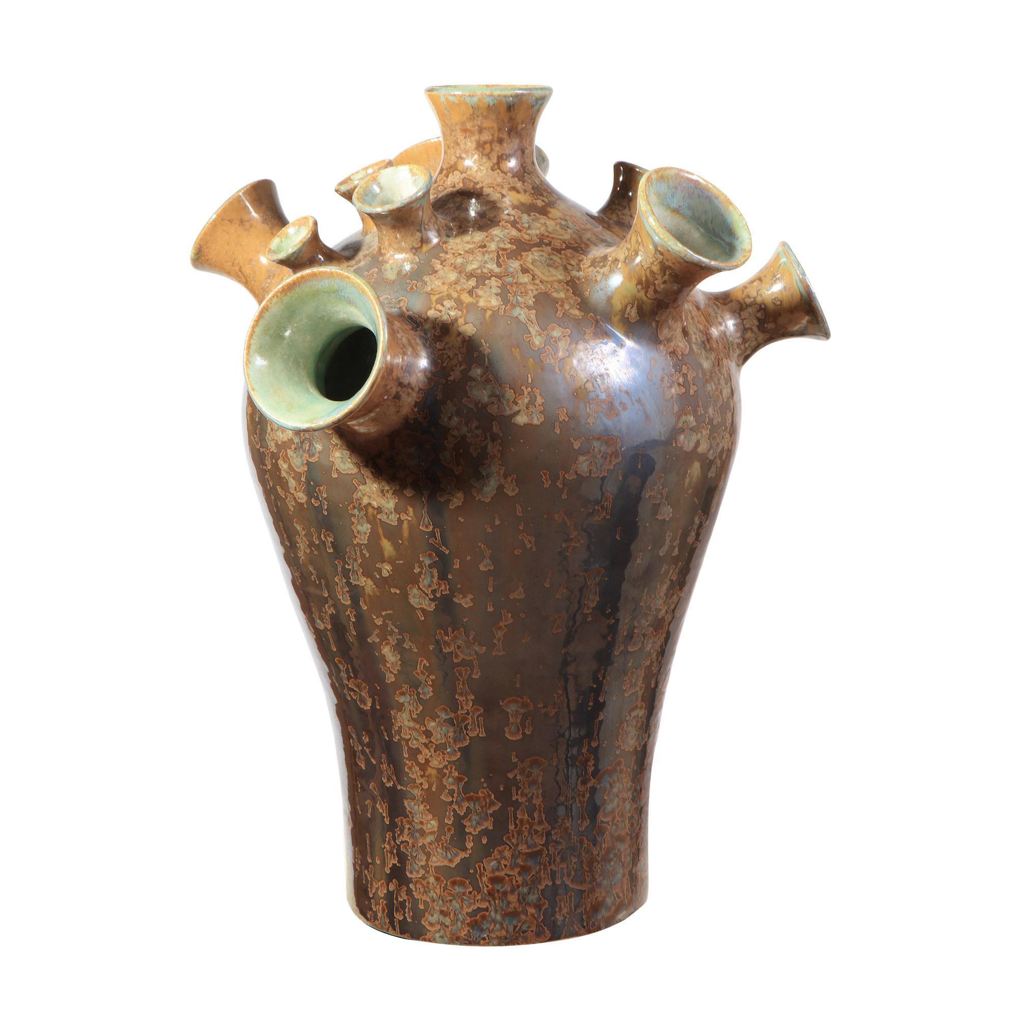 A bold and expressive sculptural lamp that reimagines traditional vessel forms through contemporary craftsmanship. Hand-thrown in porcelain, the piece features an array of broad, flaring trumpet-like necks radiating from a gracefully tapered body.