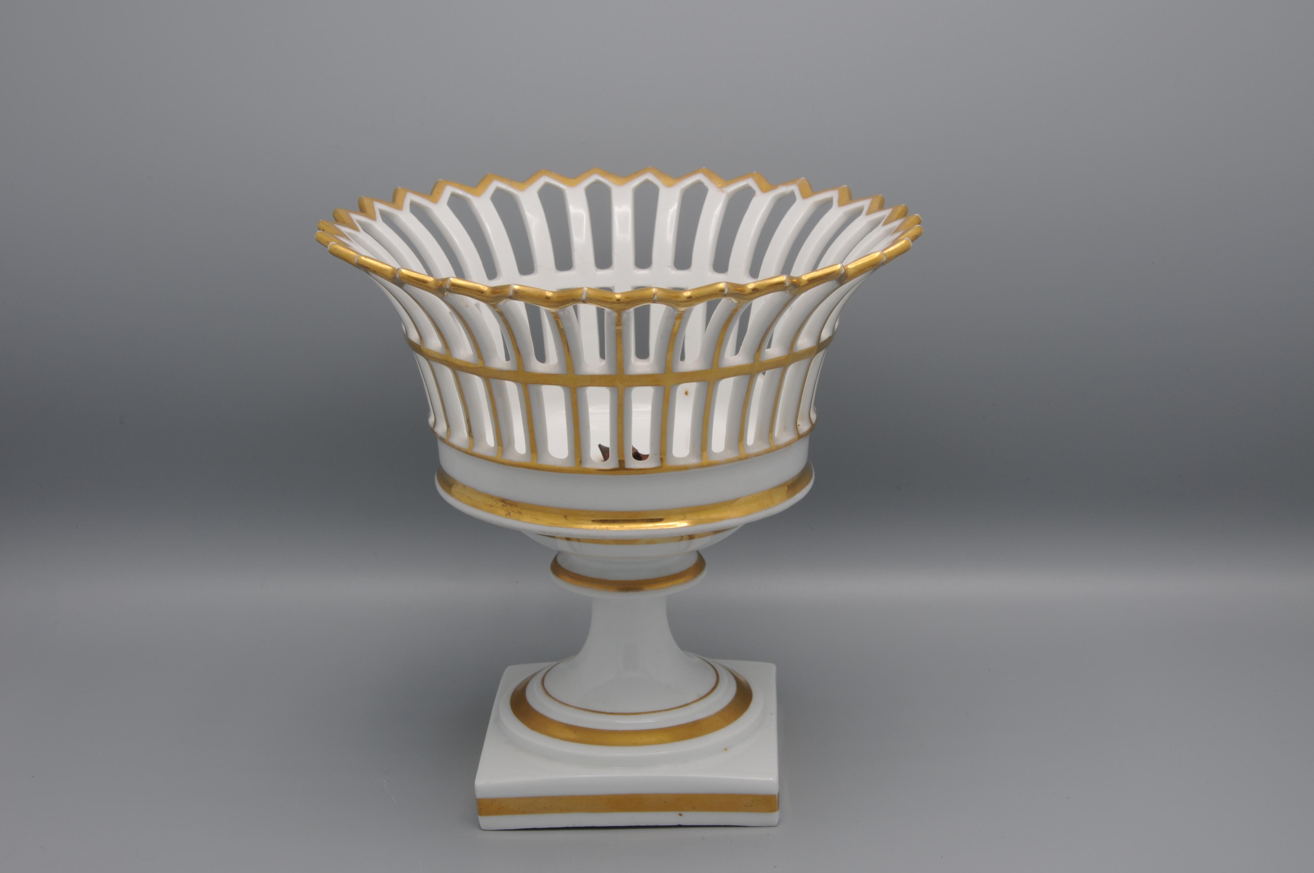 Gilt Porcelaine de Paris Openwork Coupe Centerpiece to be placed centrally on the table, for fruit or flowers. Empire Style. French, 19th century center basket, rond form with reticulated rim, on tiered square base.
Little restoration to the rim. 
