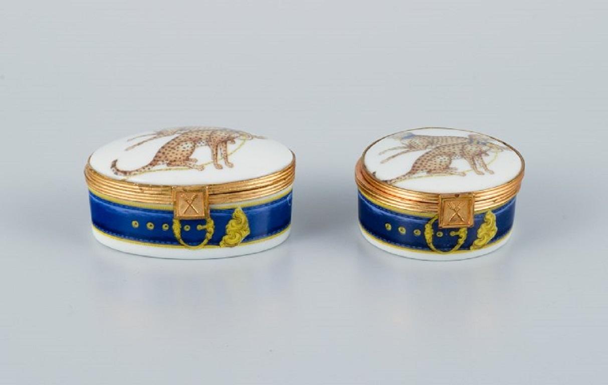 Porcelaine de Paris (Décor - Chasses Royales).
Two small lidded boxes with brass inserts hand-decorated with cheetahs and gold decoration.
Approx. 1980s.
In perfect condition.
Marked.
Round box with lid: D 5.0 ??x H 2.3 cm.
Oval lid box: L 6.5