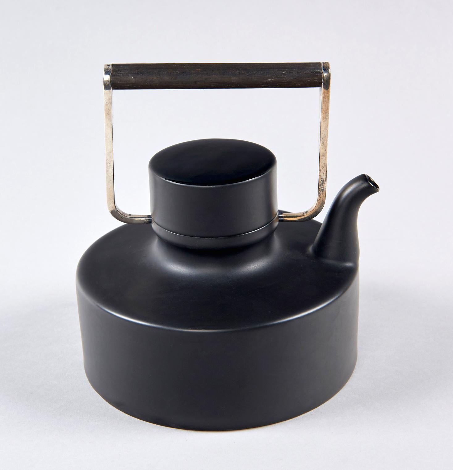Produced in Germany by Rosenthal from 1963 until 1975 in matte black porcelain (with high gloss to the top of the lid), with a handle of teak and silver-plated brass, this exquisite teapot is unmistakably the product of multidisciplinary Finnish