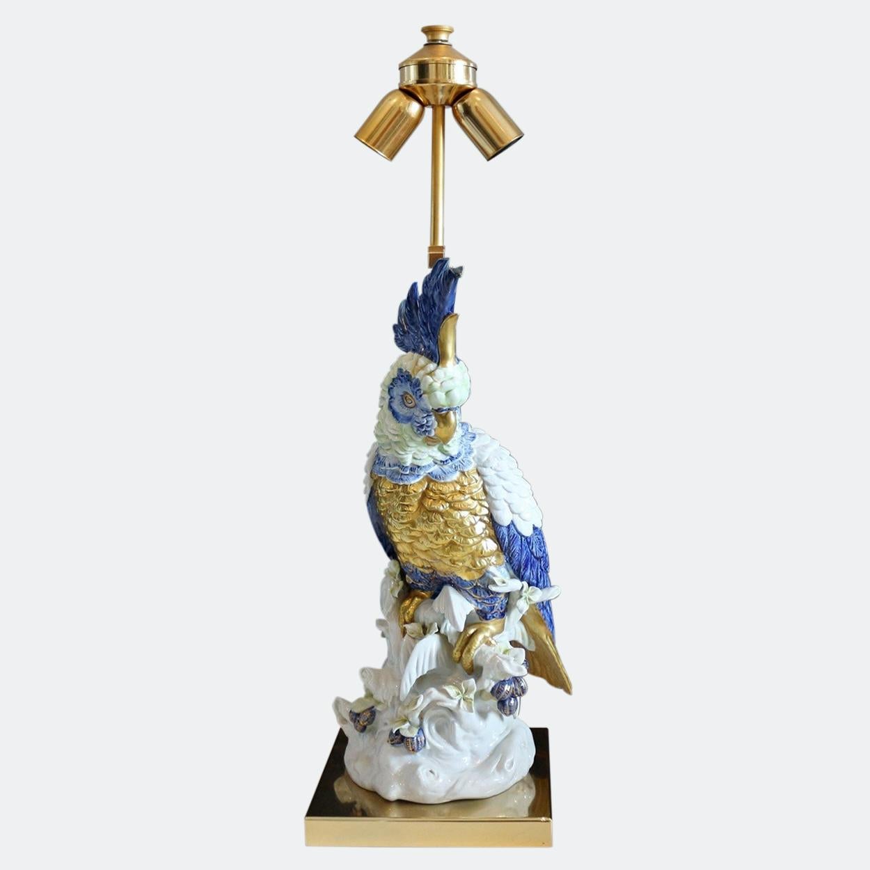 Large lamp from Italy, porcelain cockatoo mounted on a polished brass frame, the height is variable, with original shade from 83 cm to 96 cm, the shade is 52 cm wide and has the sewn-in label on the inside. Height bird 47 cm. Base plate 20 cm. 

I