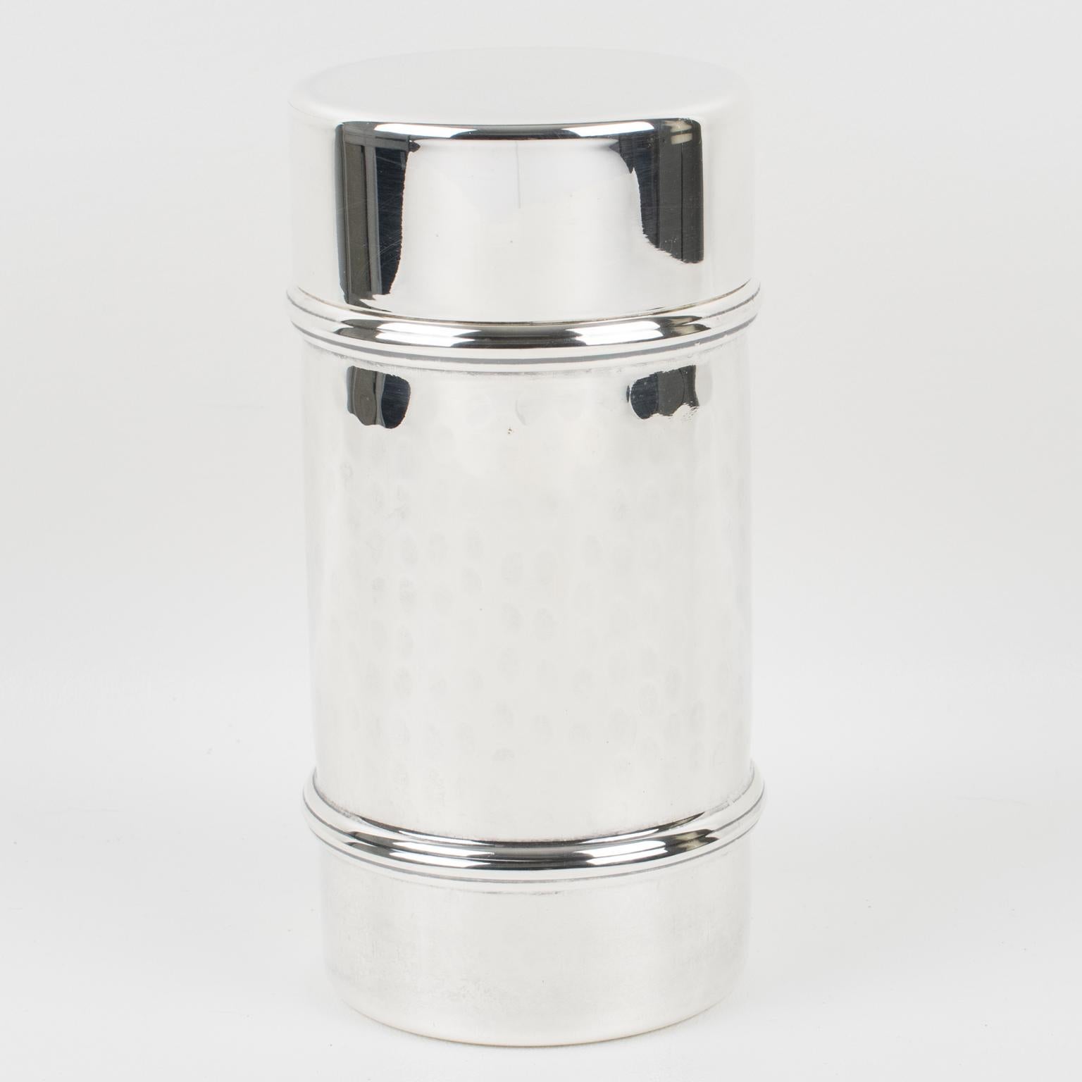 Porciani, Italy, designed this modernist silver plate cylindrical Martini or cocktail shaker. This three-sectioned cocktail shaker has a removable cap and filter strainer. The lovely minimalist shape has a slightly hammered design, and the marking