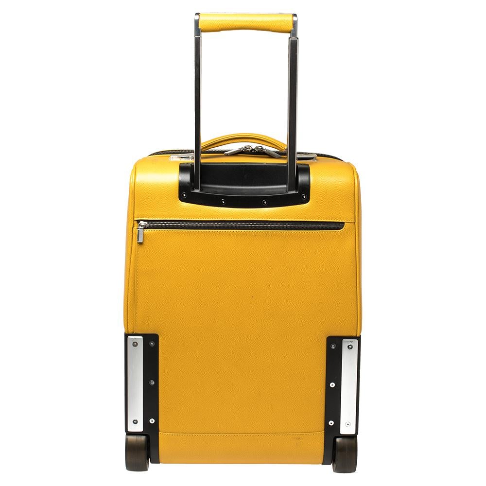 Travel in style with this Porsche trolley suitcase. This bag in yellow leather has a telescopic handle, two wheels, and a spacious nylon-lined interior that can carry all your essentials. Offering great look and durability, this carry-on luggage bag