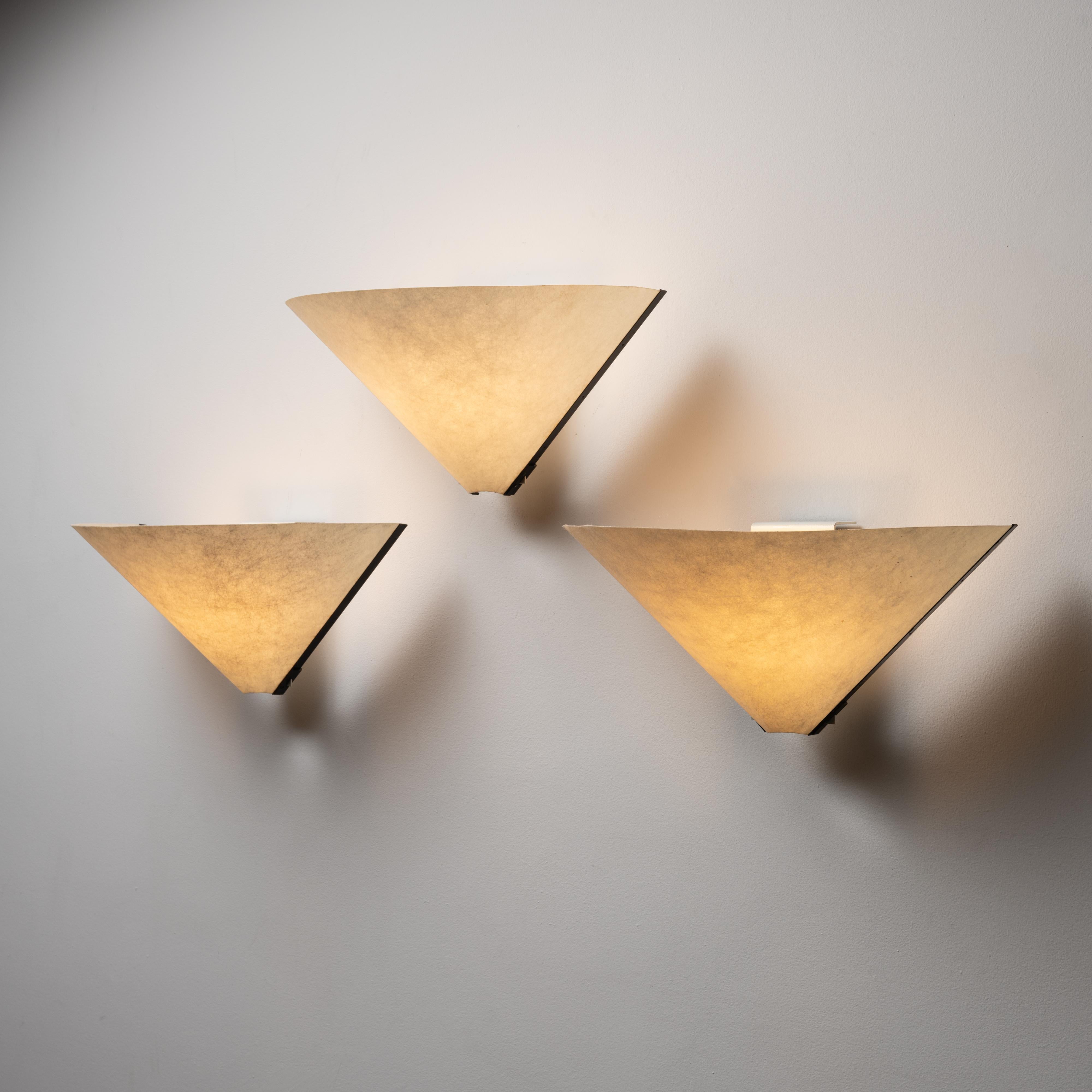 'Porsenna' wall sconces by Vico Magistretti for Artemide. Designed and manufactured in Italy, in 1977. The half-cone shade is made from a fibrous paper and provides a soft and consistent light diffusion. We recommend using a E27, 40w maximum bulb.