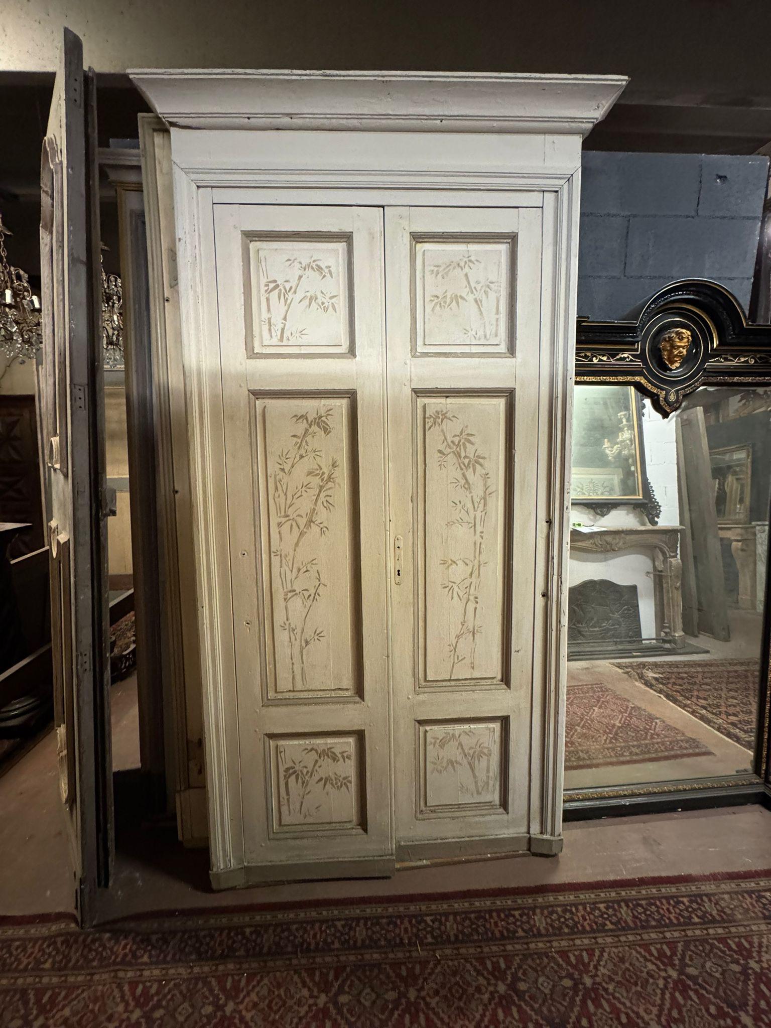 Antica porta doppia, da interno, dipinta a fondo grigio polvere con dipinto fatto a mano con tema floreale di canna di bamboo. Apertura a spingere, conserva il telaio originale con cappello superiore, originale di epoca '800, di provenienza