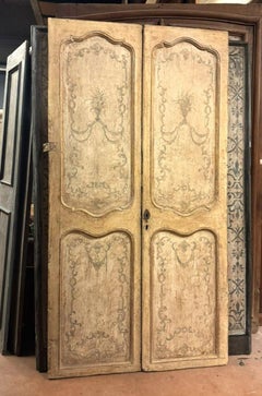 Carved and lacquered double-leaf door with painted panels, Italy