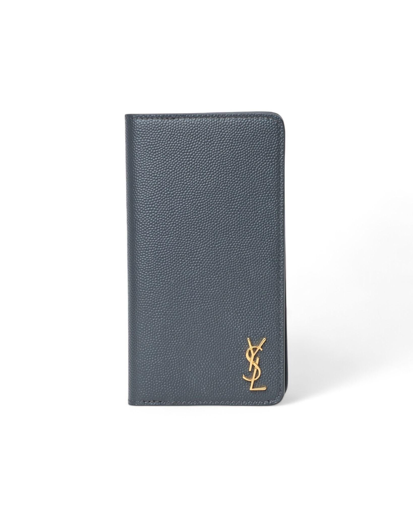 Portacellulare firmato Saint Laurent, modello Iphone XS, realizzato in pelle martellato nero con hardware dorati. Dotato di comode tasche interne per documenti. Completo di scatola e dustbag originali. L’articolo si presenta in condizioni pari al