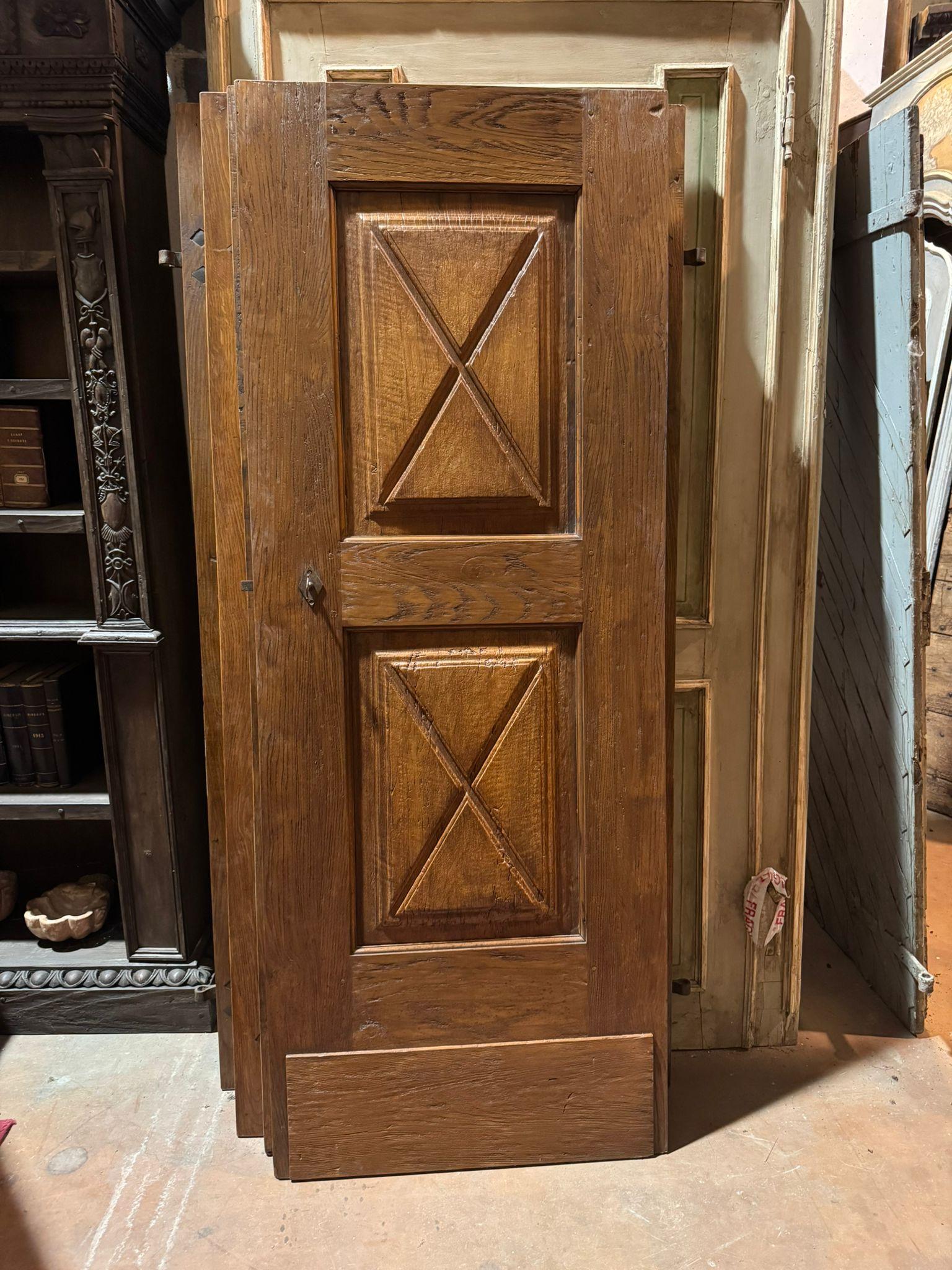 Antigua puerta de madera de álamo y roble, de uso interior y consistente en una puerta de una hoja sin marco (se montaba en la pared mediante bisagras de hierro con pulgar de pared). Conserva las bisagras originales y tiene la característica talla
