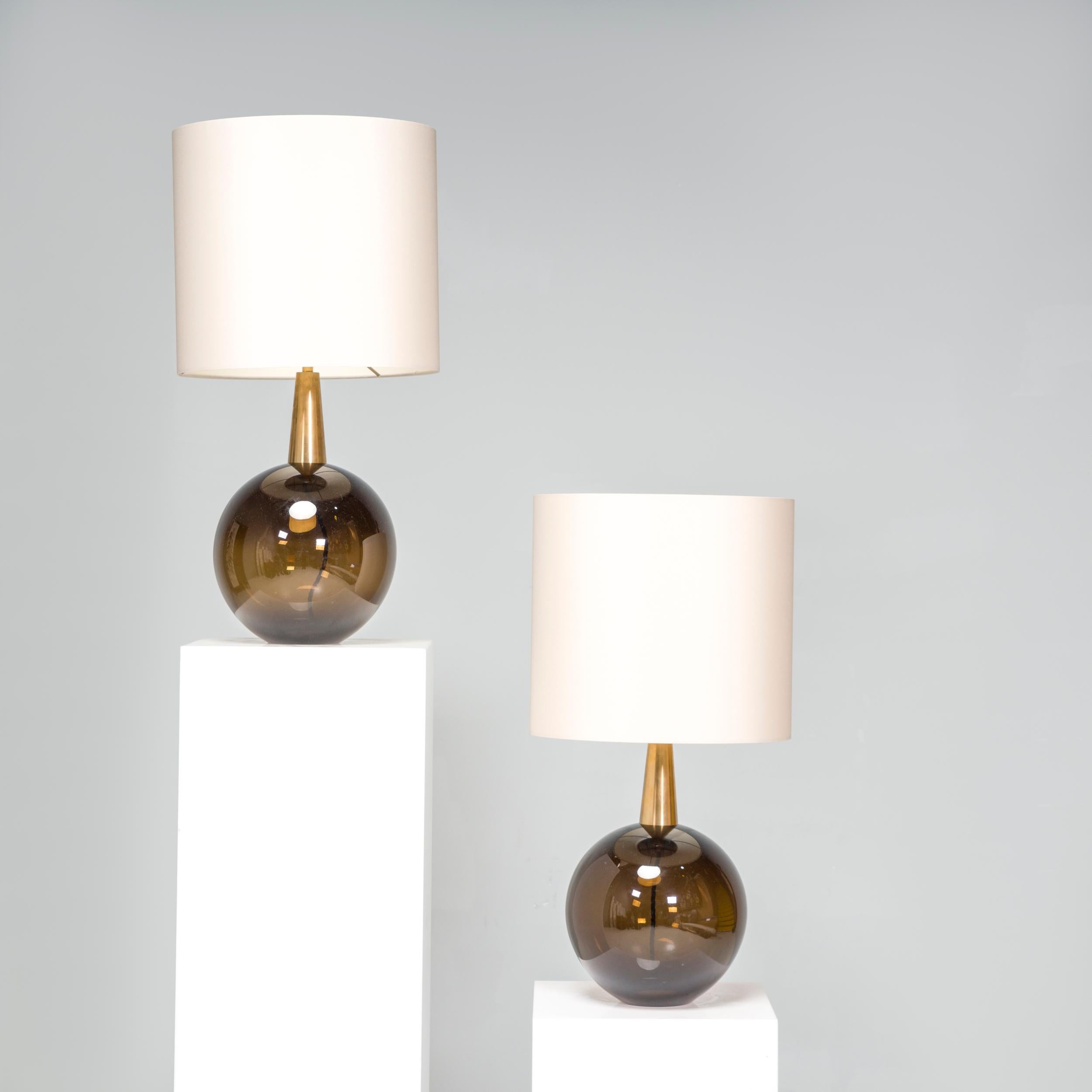 Porta Romana was founded by Andrew and Sarah Hills in 1988; their lighting is manufactured in Britain in collaboration with local artisans.  Featuring cedar brown glass bases in a sleek hourglass silhouette, the Bishop lamps have brass accents and
