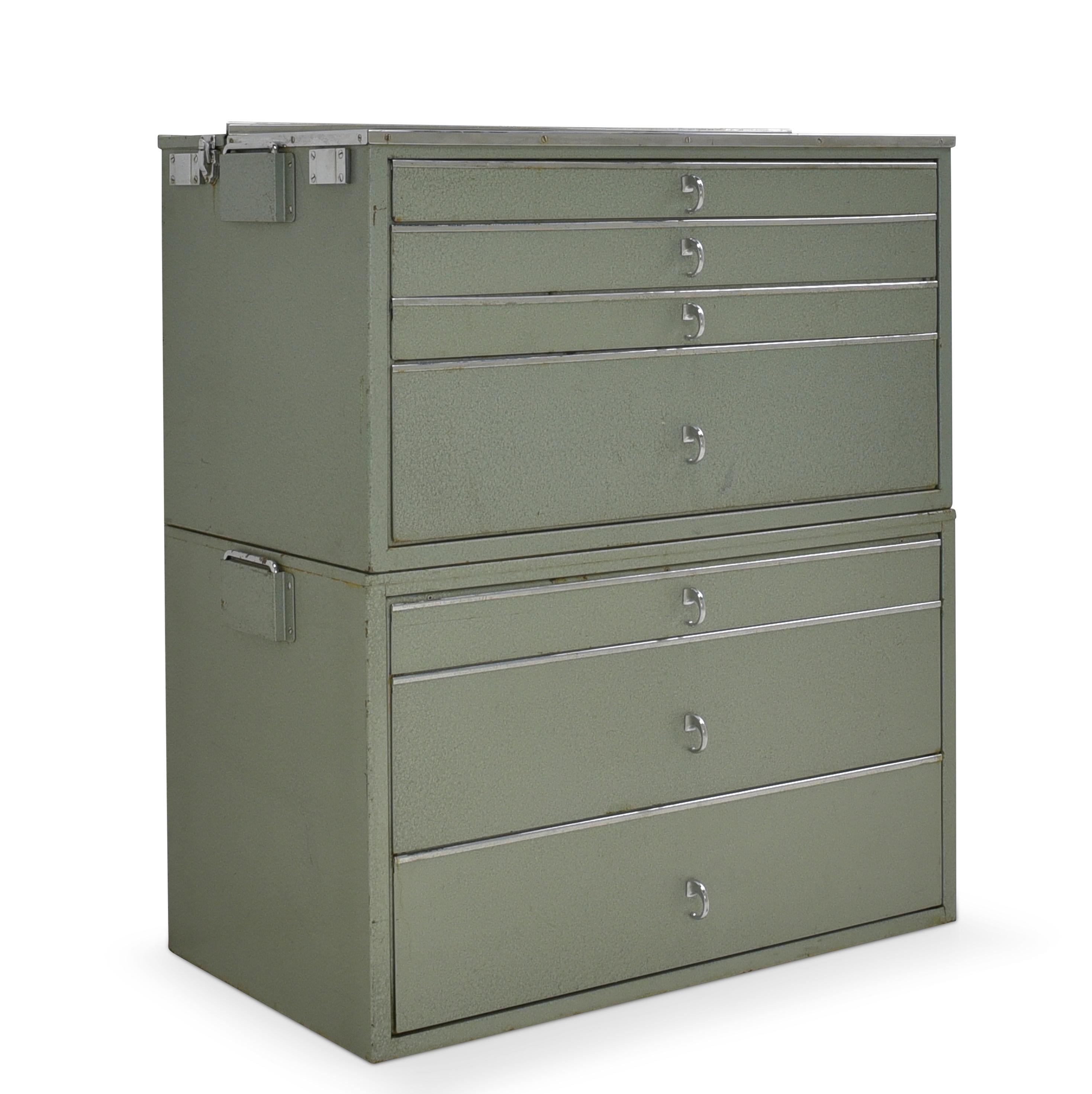 Portable Bundeswehr doctor's cabinet 2-part metal cabinet dentist's cabinet around 1970

Features:
Upper box partially hinged, partially with work surface
Both boxes with side handles
Grey-green Hammer finish
Chromed bars and handles
Some