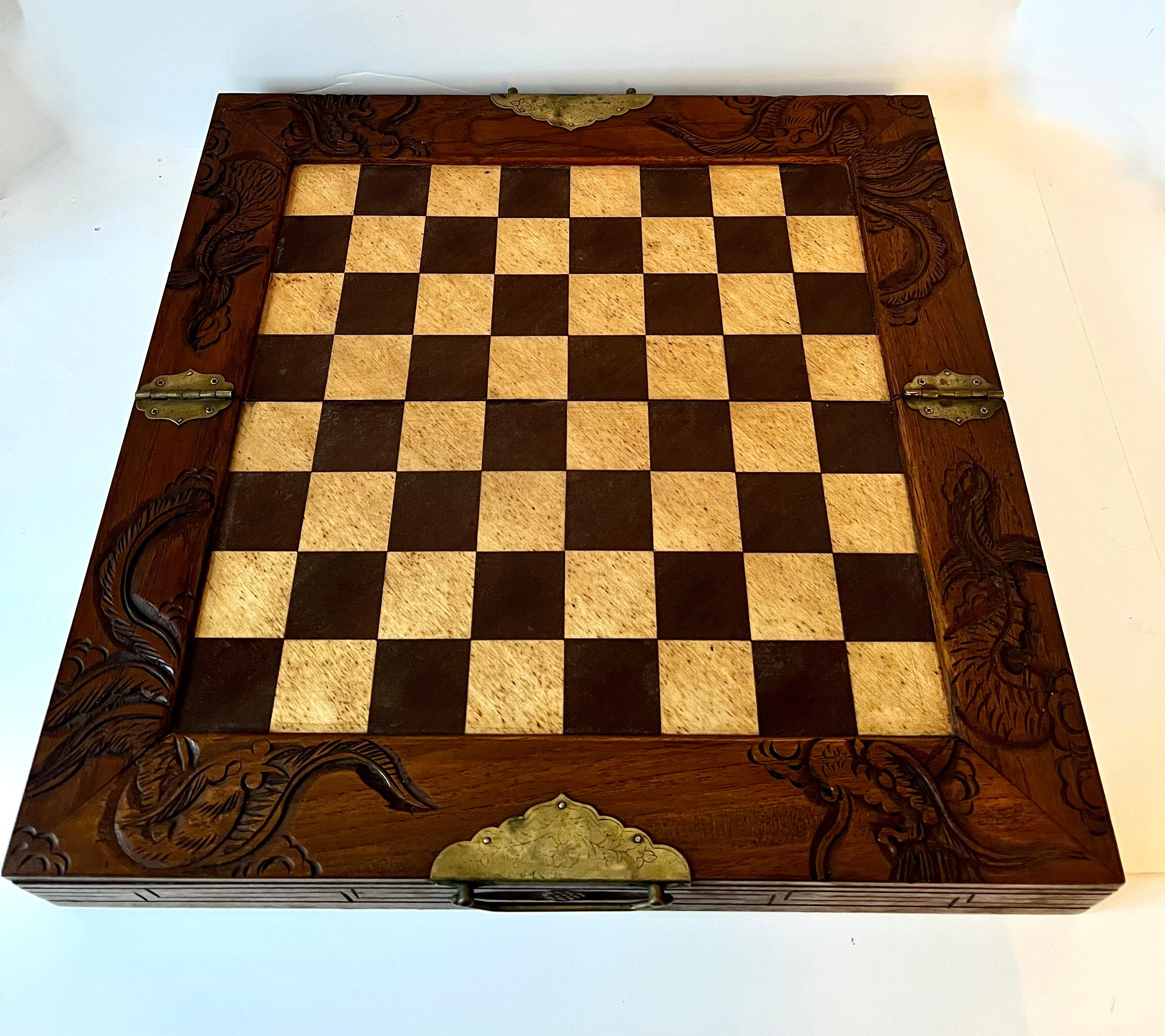 Ein wunderschönes Schachbrett (kann auch für Dame verwendet werden, nicht im Lieferumfang enthalten) mit geschnitzten Drachen am Rand. Es gibt zwei Schubladen, die jede Seite Schachfiguren halten. Das Brett hat eine schöne Patina, jede Schublade hat