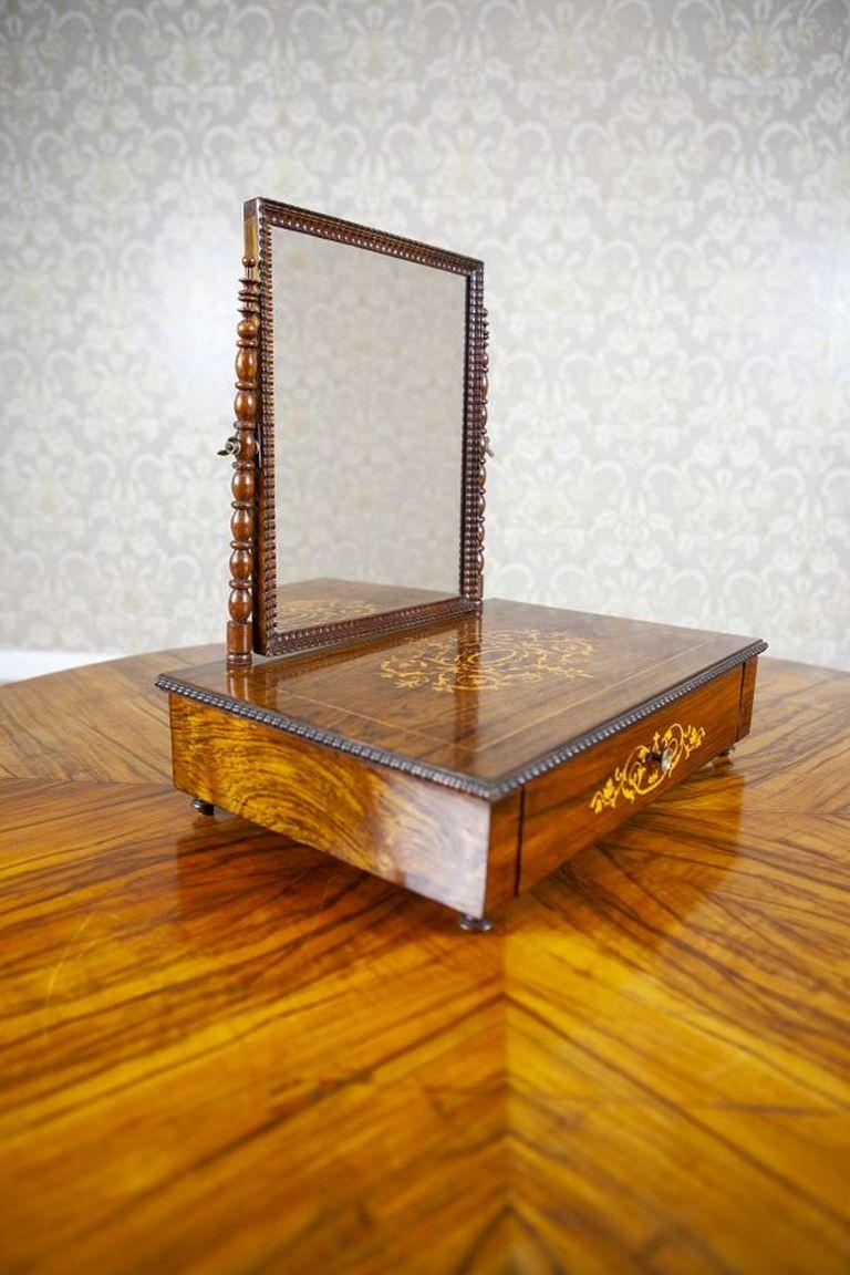 Portable, Inlaid Rosewood Dressing Table From the 1910-1920s

A small, portable dressing table from the early 20th century in the form of a rectangular box with a movable mirror mounted on two turned supports. The box is veneered with rosewood, with