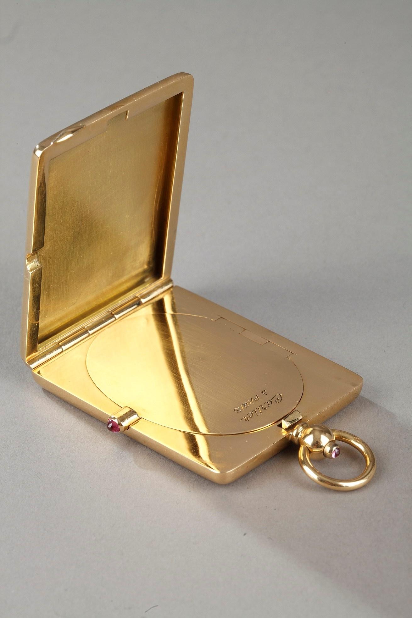 Rectangular gold case or box signed Cartier in Paris. The case is finely guilloché with rhombic motifs and framed by a stylized foliated frieze. The case includes a bail. The push button set with a cabochon tourmaline opens the case. Inside a system