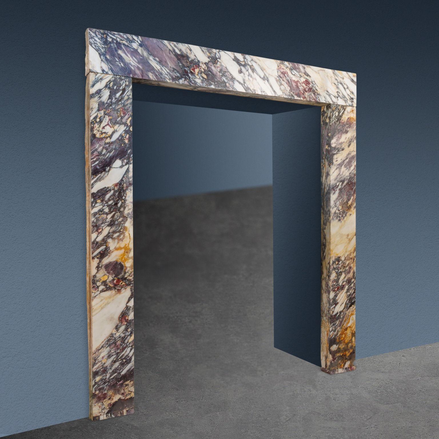 Un portal palaciego de brecha medicea, un tipo de mármol que debe su nombre a su amplio uso por parte de la familia Médicis en la Toscana del siglo XVI para revestimientos y decoración. Formado por un par de elementos portantes verticales sobre los