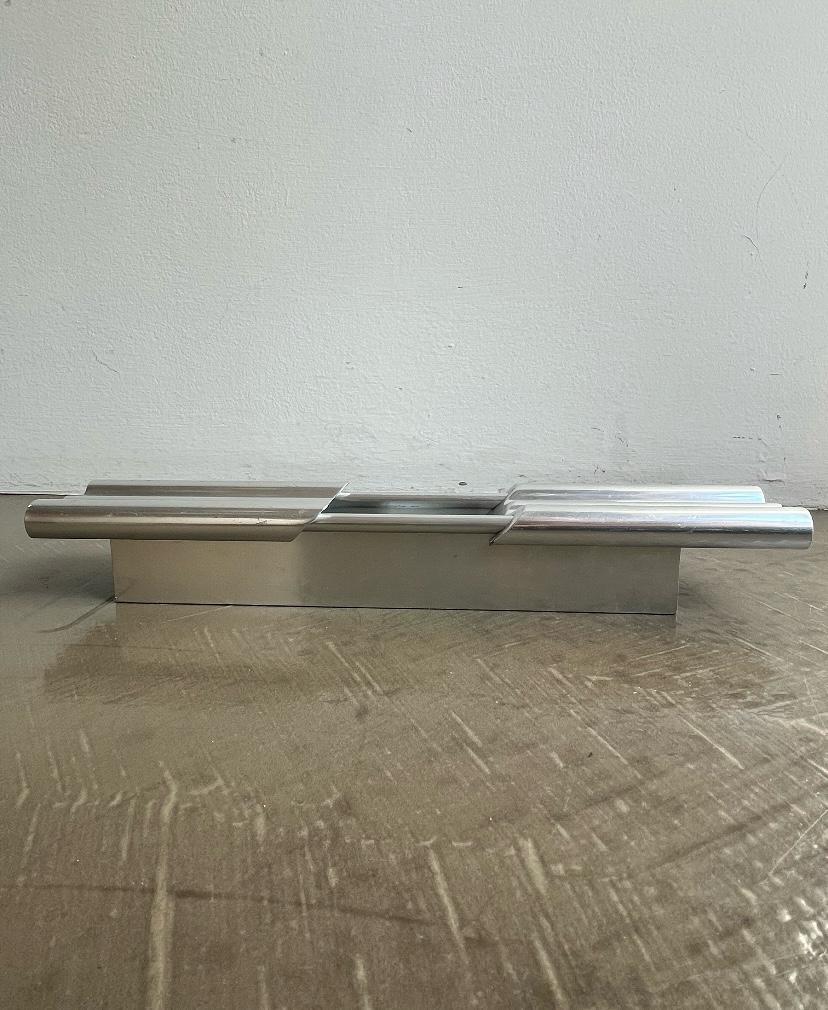Cenicero o soporte de aluminio extruido, Nucleo, Enrico Panzeri para Sormani, 1967, Italia
Objeto funcional, cenicero o bandeja de vaciado, de aluminio extruido, perteneciente a la línea Nucleo producida por Sormani en 1967. El diseño se caracteriza