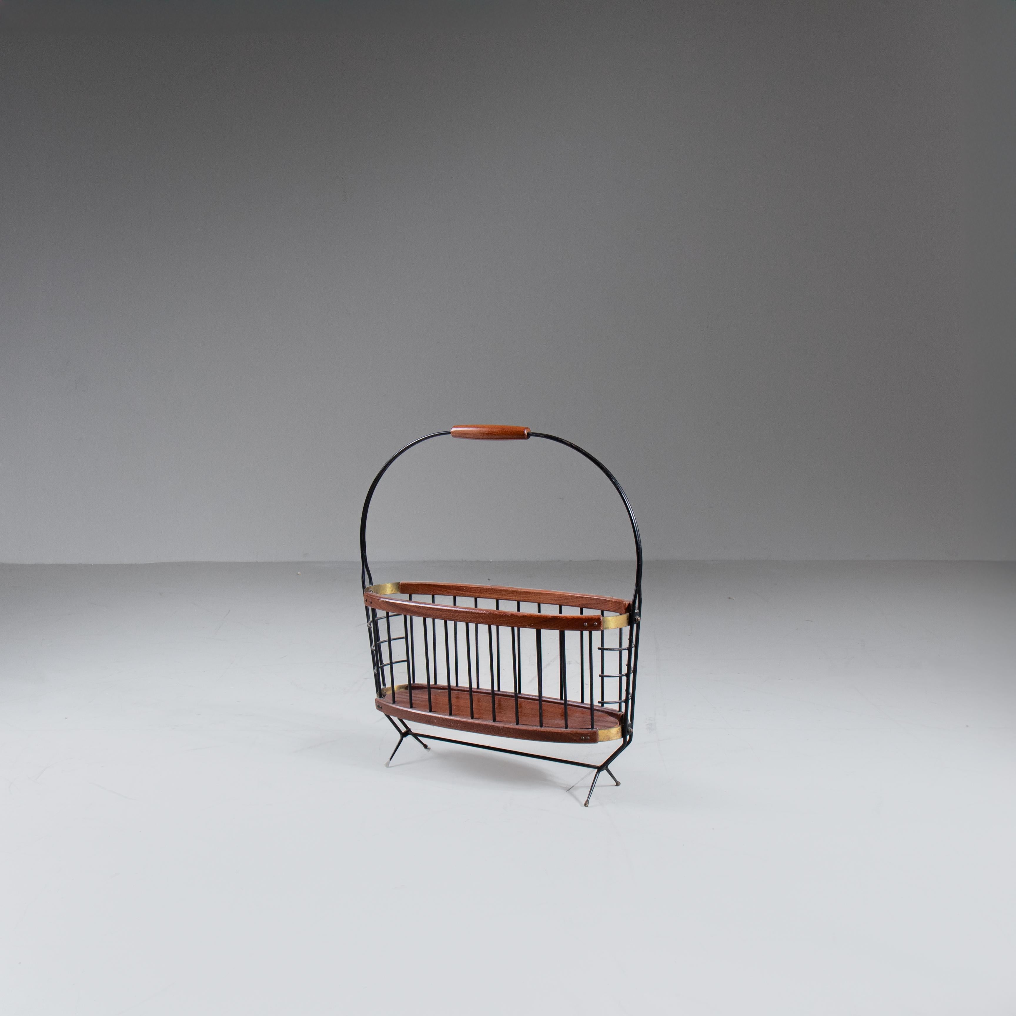 Portariviste in legno e metallo, mid-century, produzione italiana, 1960. Struttura in metallo con finitura nera e scomparto in legno sagomato per contenere riviste e giornali. Il design essenziale e le linee pulite richiamano l’estetica modernista