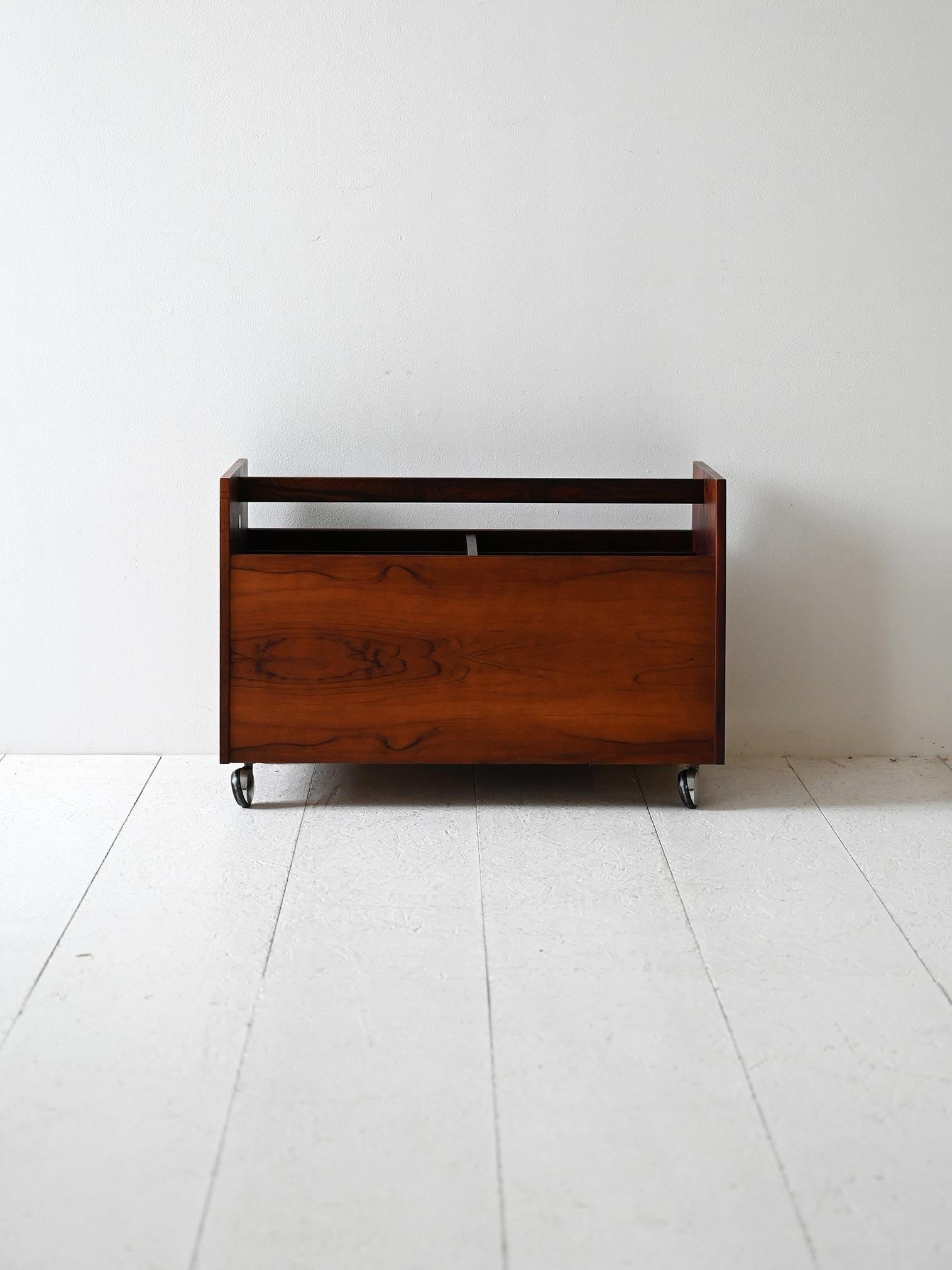 Portariviste anni ’60 in palissandro con scomparti interni e struttura su rotelle. Linee inclinate e finitura materica.

Portariviste vintage scandinavo degli anni ’60 realizzato in palissandro, con venature a vista e struttura inclinata. Dotato di