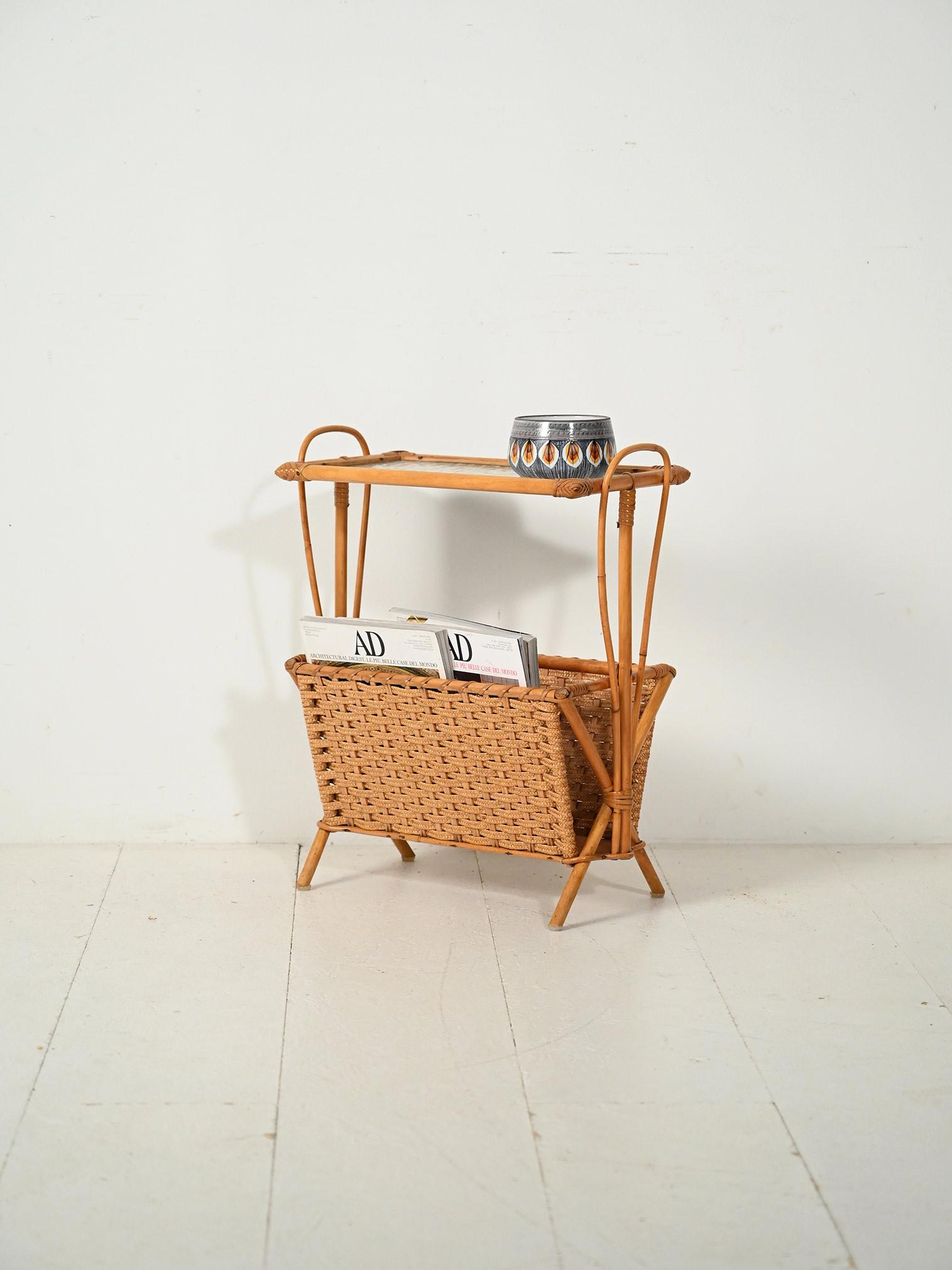 Portariviste scandinavo anni '60 in bambù intrecciato, struttura leggera con cesto lavorato e ripiano superiore in vetro.

Structure en canne de bambou avec des montants incurvés et des jambes en vue ; à la base, un cesto en bambou intrecciato