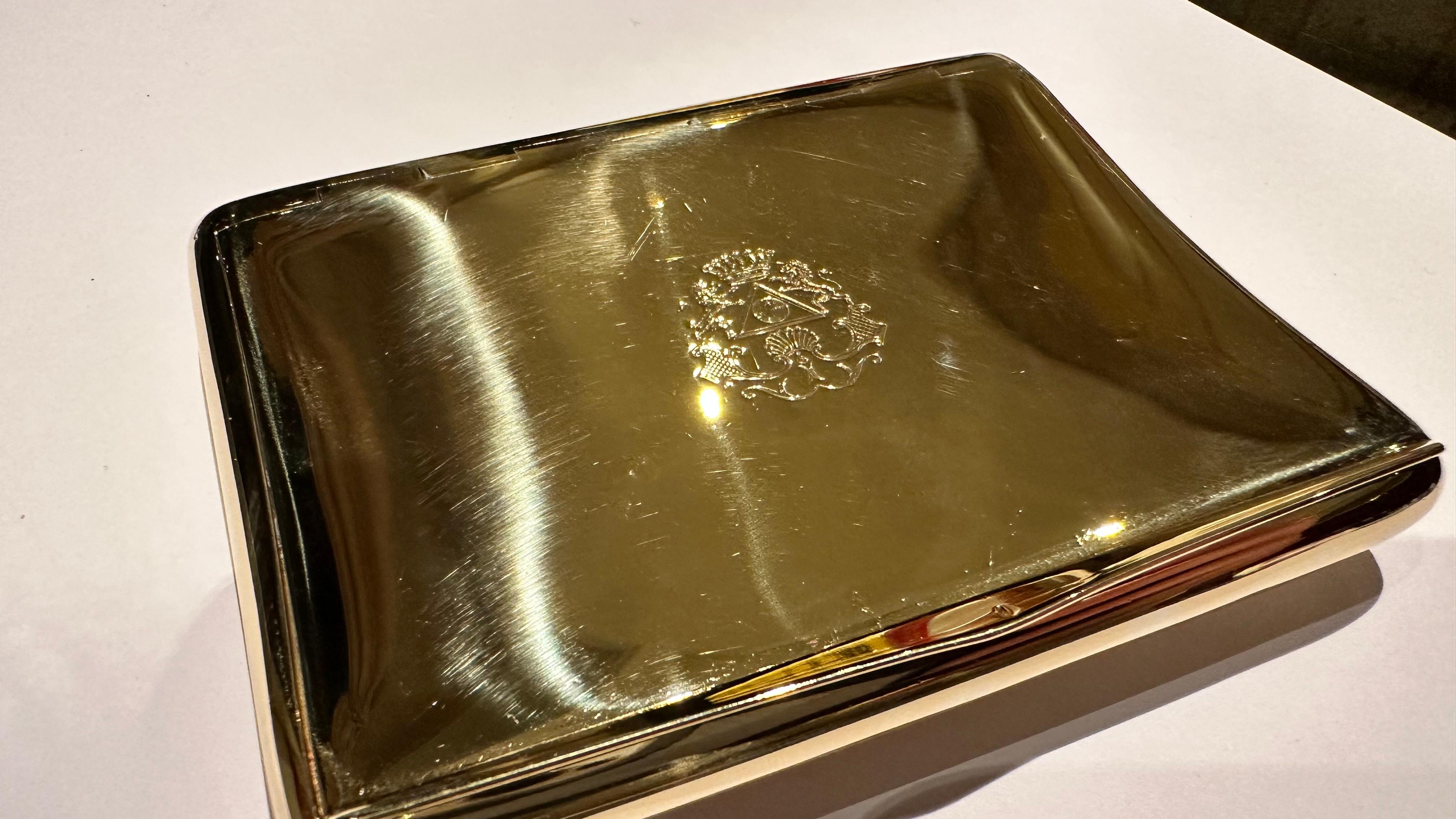 Objet d'une rare beauté et d'un grand prestige, cet étui à cigarettes en or jaune massif incarne l'élégance et le luxe d'une époque révolue. Entièrement réalisé en or 18 carats, le design minimaliste mais imposant est orné d'une gravure centrale
