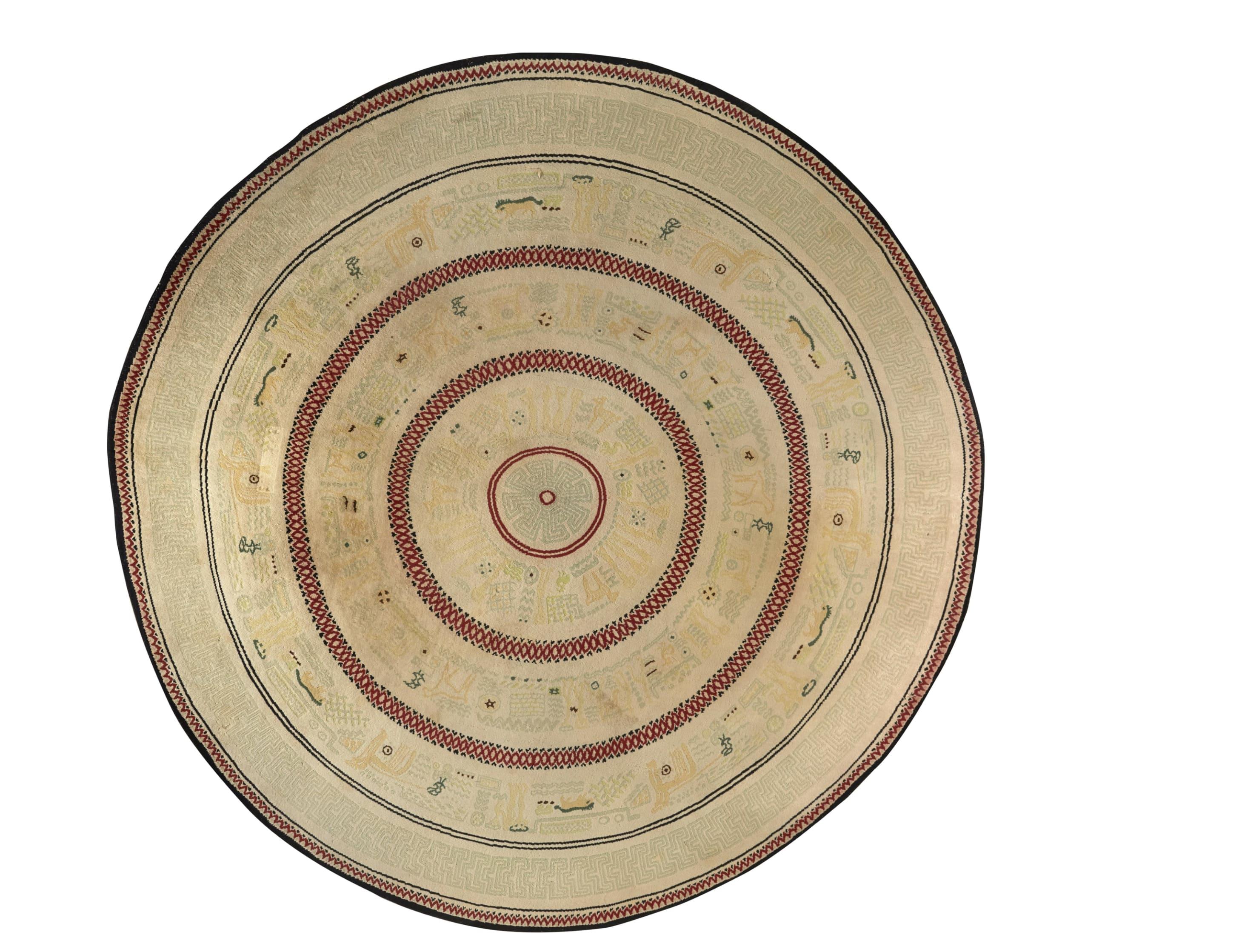 Importante tappeto circolare in lana, unico nel suo genere, con decorazione concentrica di fregi geometrici rossi e neri formati da pittogrammi e ideogrammi aztechi gialli e grigi su sfondo crema, disegnato da Alfred Porteneuve e Sallandrouze Frères